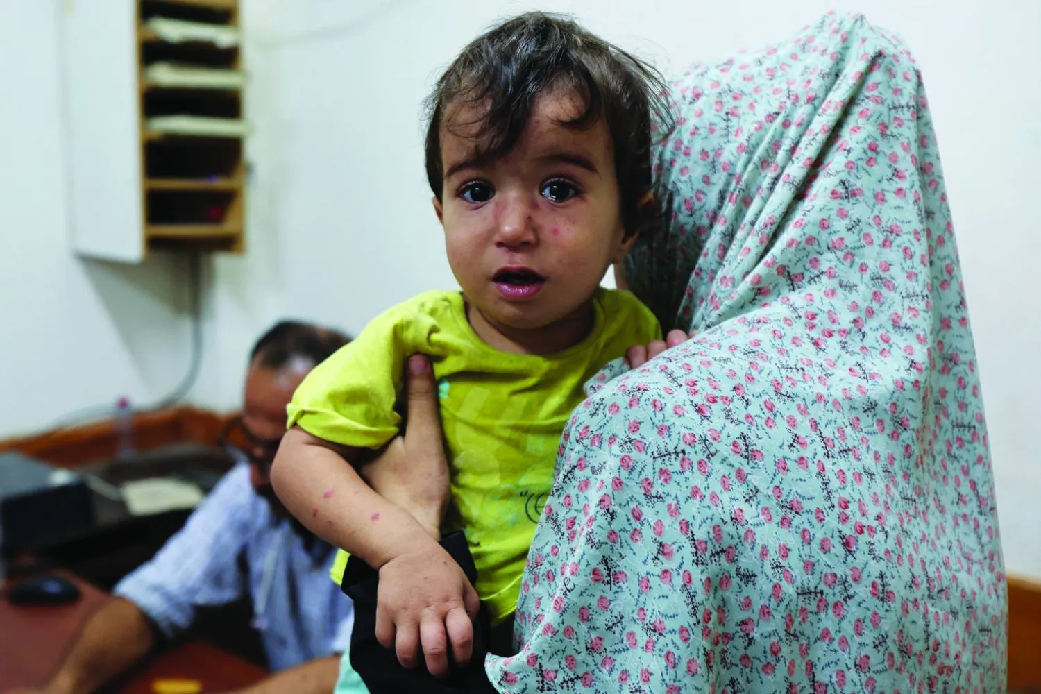 A Palestinian child looks on while being examined by a doctor at Al-Aqsa Martyrs Hospital, amid fears over the spread of polio after the first case was reported by the Ministry of health, as the conflict between Israel and Hamas continues, in Deir Al-Balah in the central Gaza Strip, August 18, 2024. REUTERS/Ramadan Abed