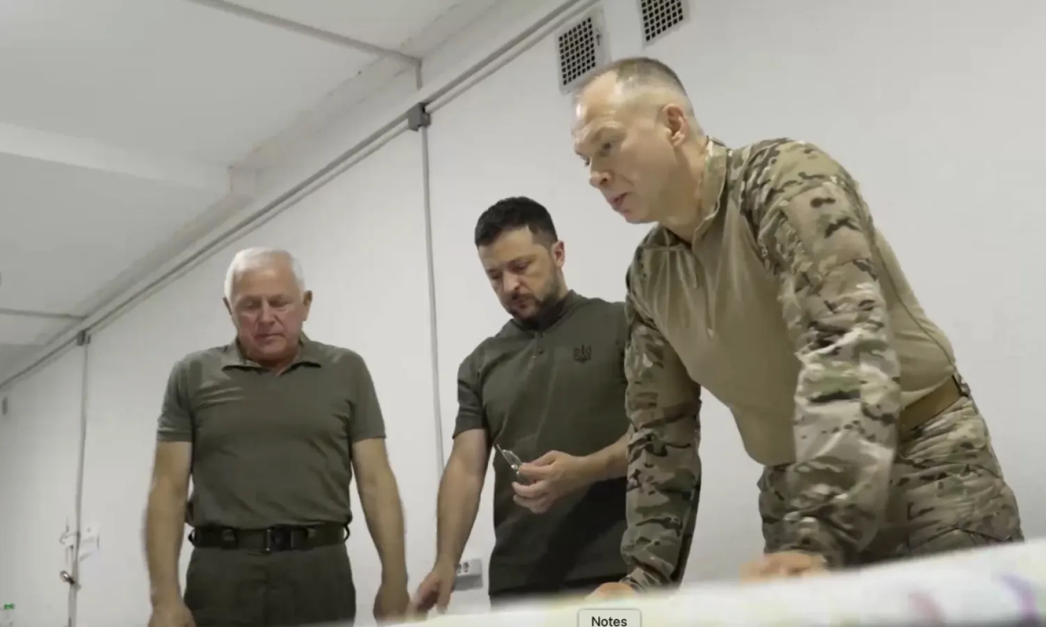 In this photo provided by the Ukrainian Presidential Press Office, Ukrainian President Volodymyr Zelenskyy, center, Commander-in-Chief Oleksandr Syrsky, right, look at a map during their visit to Sumy, Ukraine, Thursday, Aug. 22, 2024. (Ukrainian Presidential Press Office via AP)