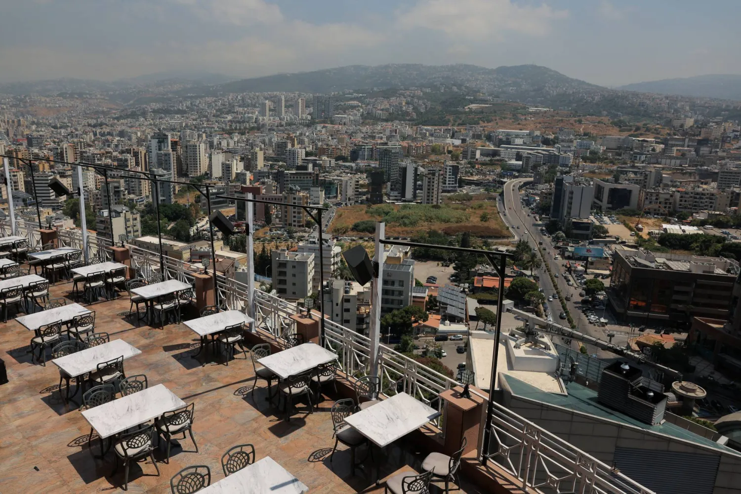 Empty tables stand at an empty restaurant at the Hilton Beirut Metropolitan Palace, with a general view visible in the background, in Beirut, Lebanon, August 19, 2024. REUTERS/Amr Alfiky