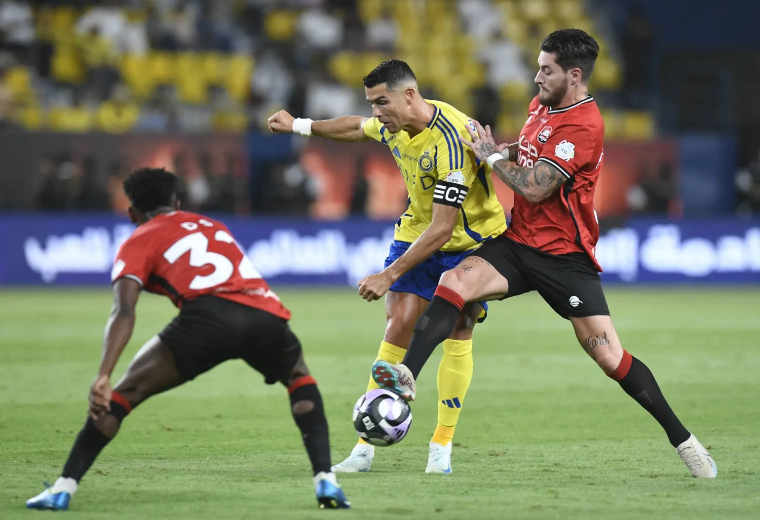 رونالدو محاصرا من لاعبي الرائد خلال إحدى الهجمات النصراوية (رويترز)