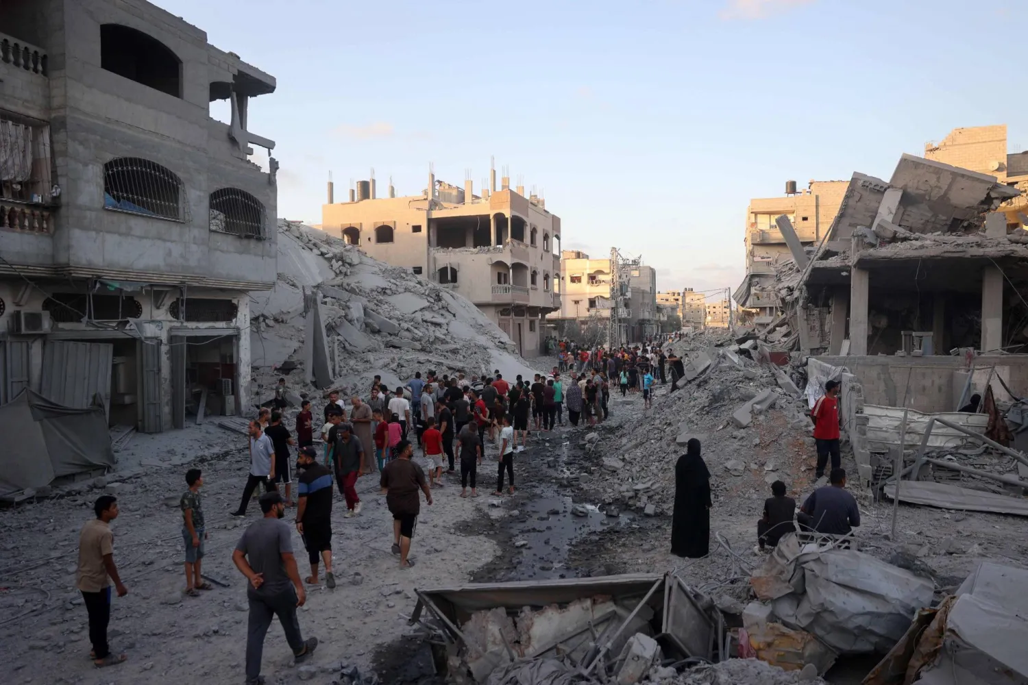 Palestinians gather to check a building shortly after it was levelled by Israeli bombing in the Nuseirat refugee camp in the central Gaza Strip on August 22, 2024, as the conflict between Israel and the Hamas group continues. (Photo by Eyad BABA / AFP)