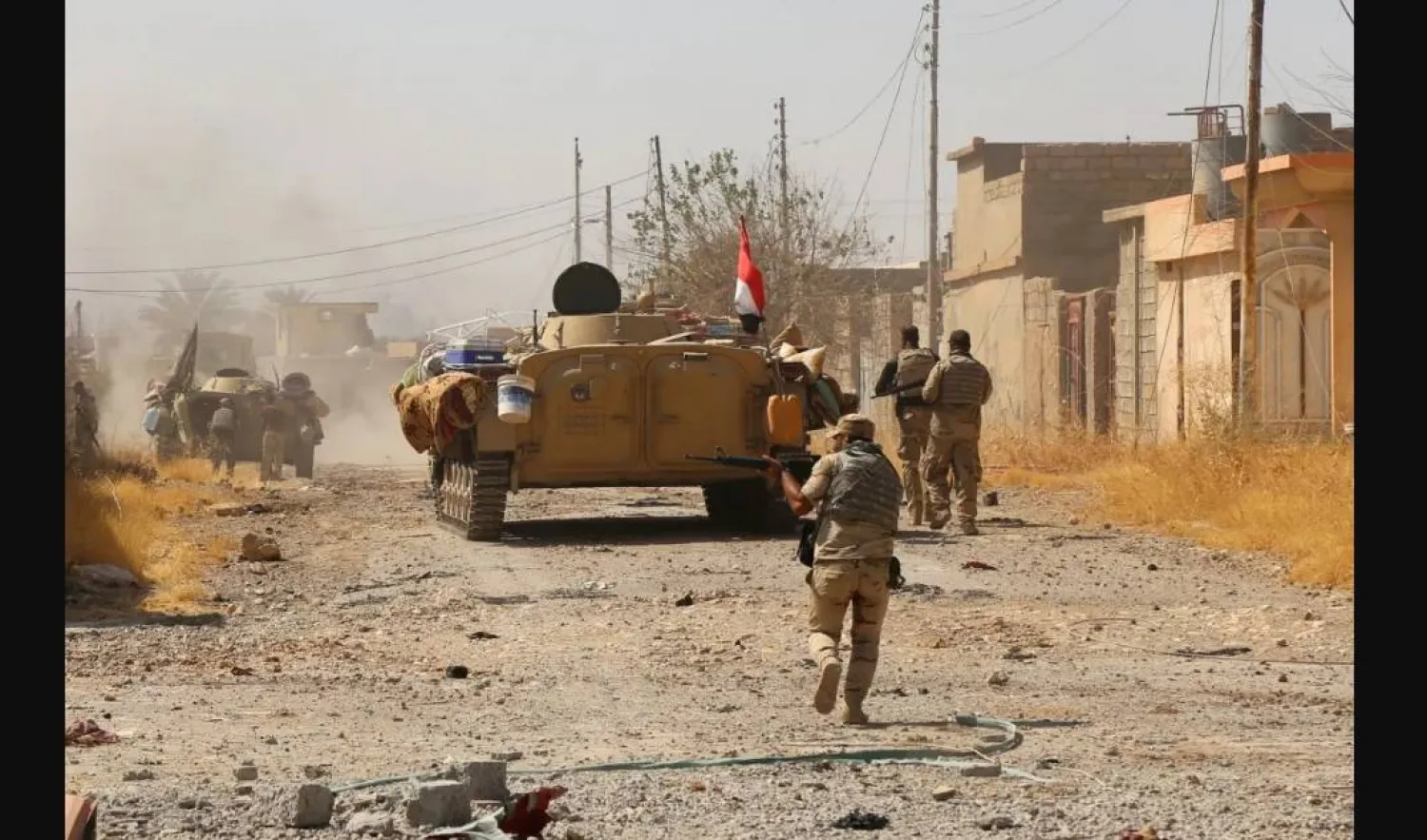 عناصر من الجيش العراقي يظهرون في أثناء اشتباكات مع مسلحين إرهابيين (رويترز)