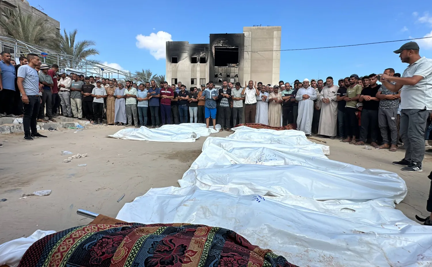 أقارب فلسطينيين  قُتلوا في الهجمات الإسرائيلية يؤدون صلاة الجنازة أمام جثامينهم قبل دفنهم في مستشفى ناصر بعد أن شنّ الجيش الإسرائيلي هجوماً على مدينة حمد ومناطق أخرى في خان يونس (د.ب.أ)