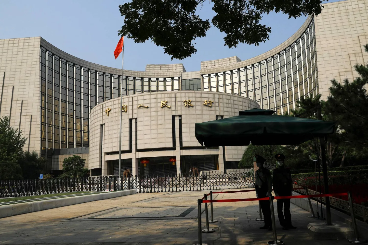 FILE PHOTO: Paramilitary police officers stand guard in front of the headquarters of the People's Bank of China, the central bank (PBOC), in Beijing, China September 30, 2022. REUTERS/Tingshu Wang/File Photo
