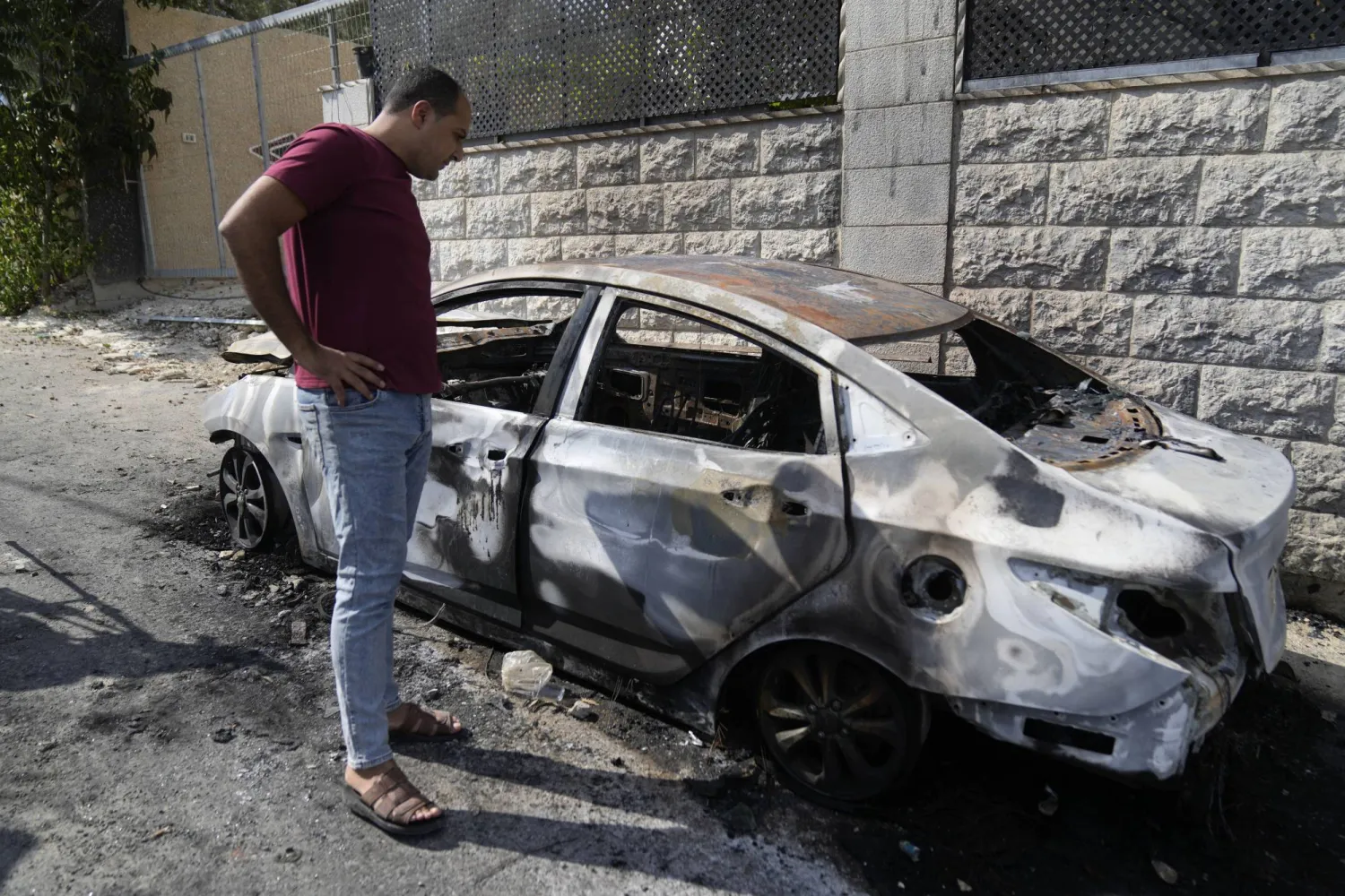 فلسطيني يعاين سيارة أحرقها المستوطنون «شبيبة التلال» في بلدة جيت بالضفة الغربية أغسطس الجاري (أ.ب)