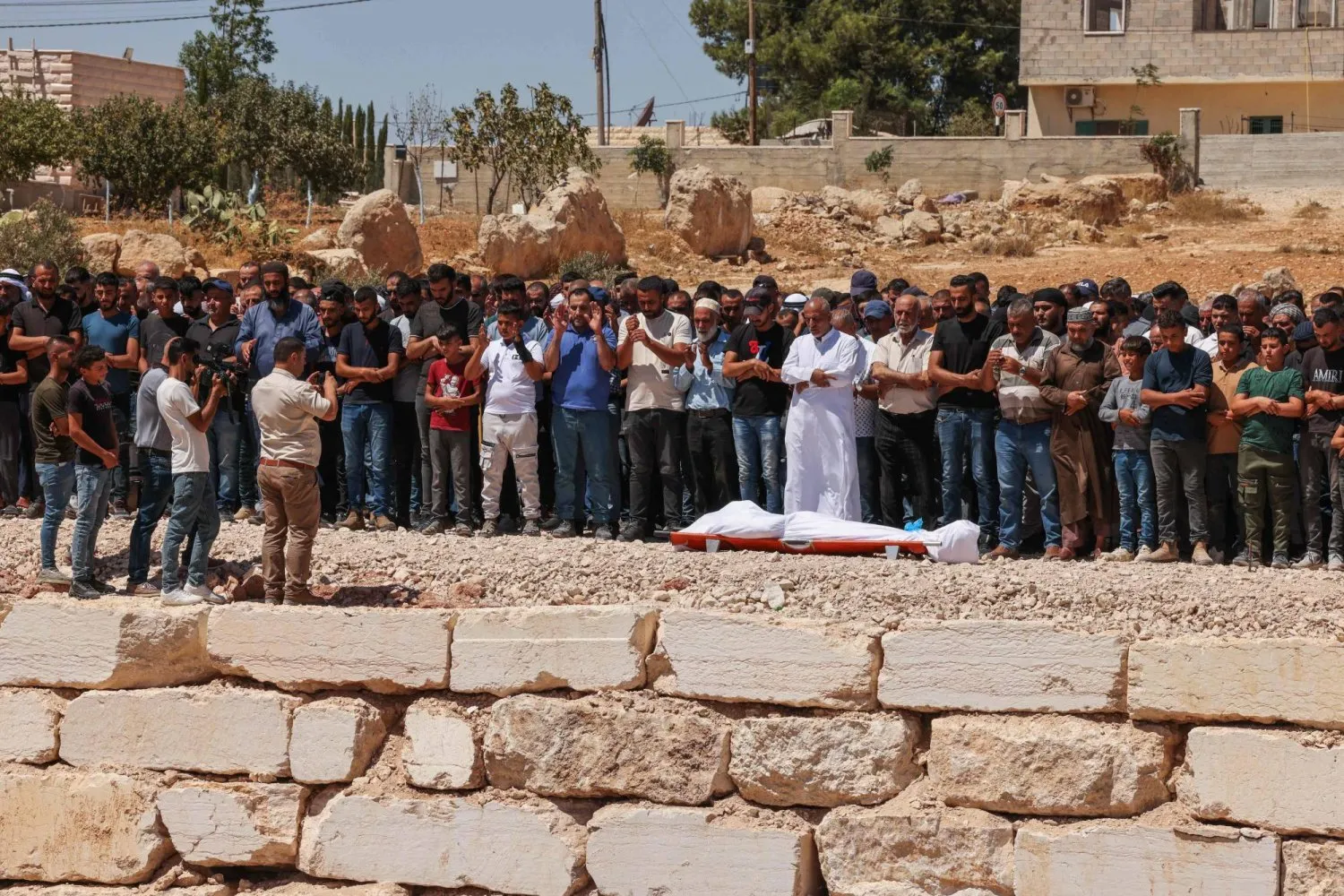 Batı Şeria'nın El Halil kentinin güneyinde İsrail güçleri tarafından öldürülen bir kişinin cenaze namazı kılan Filistinliler (AFP)