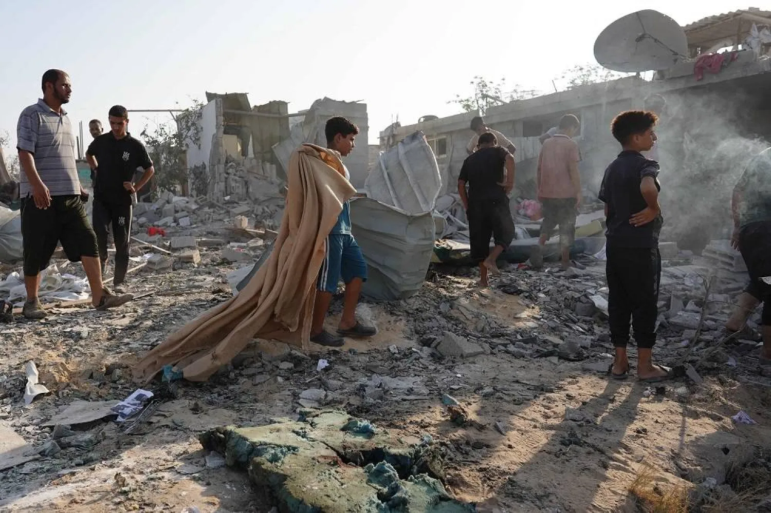 Palestinians inspect the damage following Israeli bombardment on Khan Younis in the southern Gaza Strip on August 27, 2024, amid the ongoing conflict between Israel and the Hamas group. (AFP)
