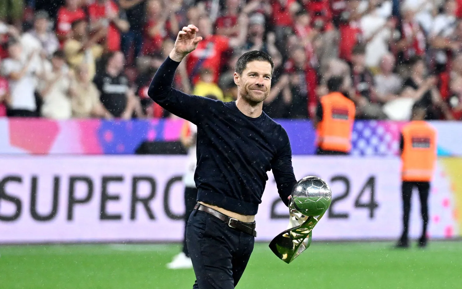 تشابي ألونسو حاملاً كأس السوبر الألماني (أ.ف.ب)