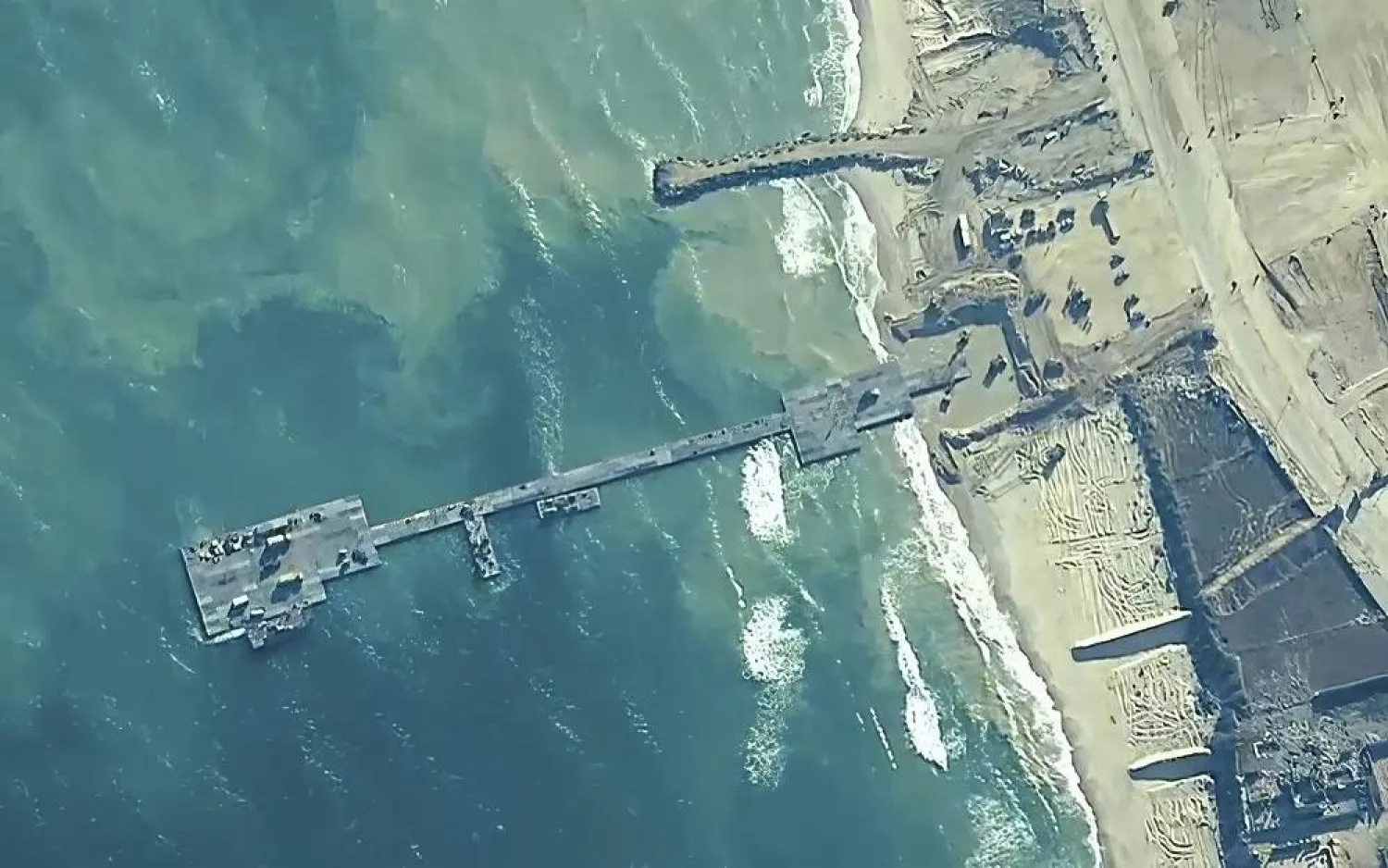 The image provided by US Central Command, shows US Army soldiers assigned to the 7th Transportation Brigade (Expeditionary), US Navy sailors assigned to Amphibious Construction Battalion 1, and Israel Defense Forces placing the Trident Pier on the coast of Gaza Strip on May 16, 2024. (US Central Command via AP, File) 