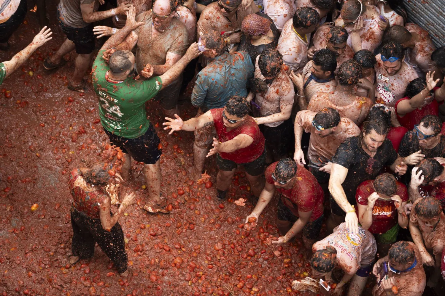 مشاركون يرمون الطماطم على بعضهم بعضاً خلال مهرجان بإسبانيا (د.ب.أ)