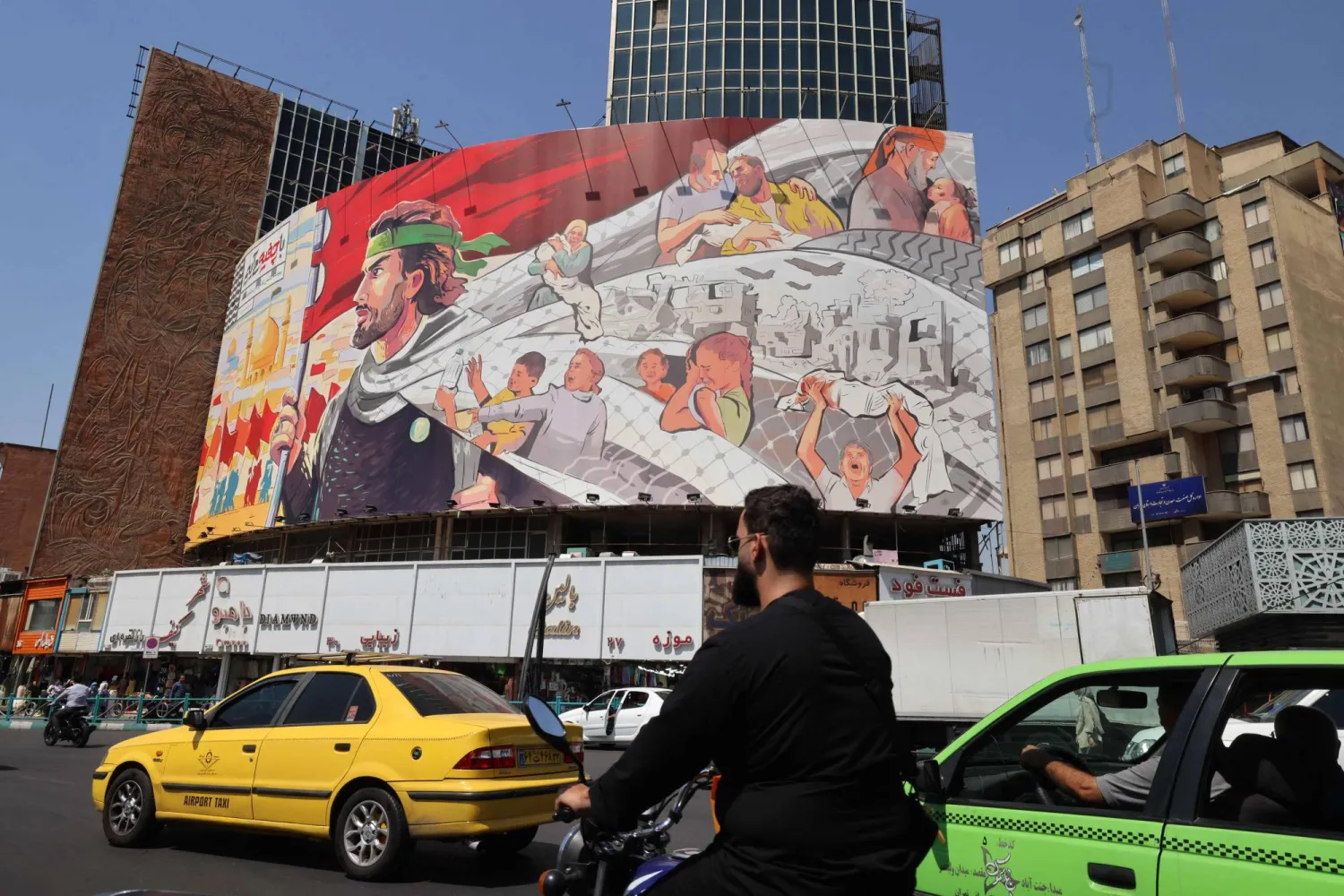 Motorists drive under an anti-Israel poster in the capital Tehran on August 27, 2024. (Photo by ATTA KENARE / AFP)