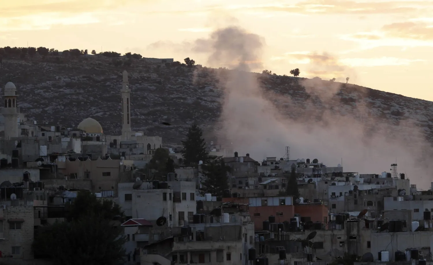 الدخان يتصاعد فوق مخيم «جنين» للاجئين خلال عملية عسكرية إسرائيلية في الضفة الغربية (إ.ب.أ)