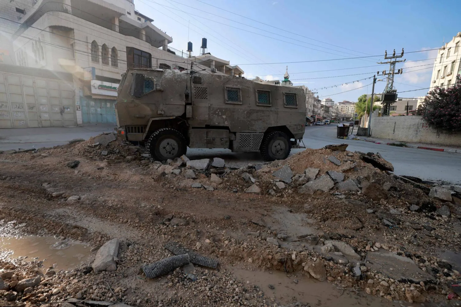 مركبة عسكرية إسرائيلية تسير على الطريق خلال مداهمة في مدينة طولكرم (أ.ف.ب)