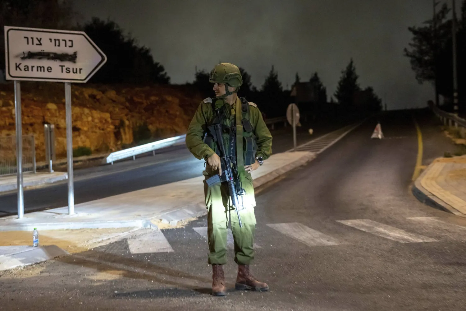 An Israeli soldier stands guard the near the scene of a car that exploded in the West Bank settlement of Karme Tsur, Saturday, Aug. 31, 2024. (AP Photo/Ohad Zwigenberg)