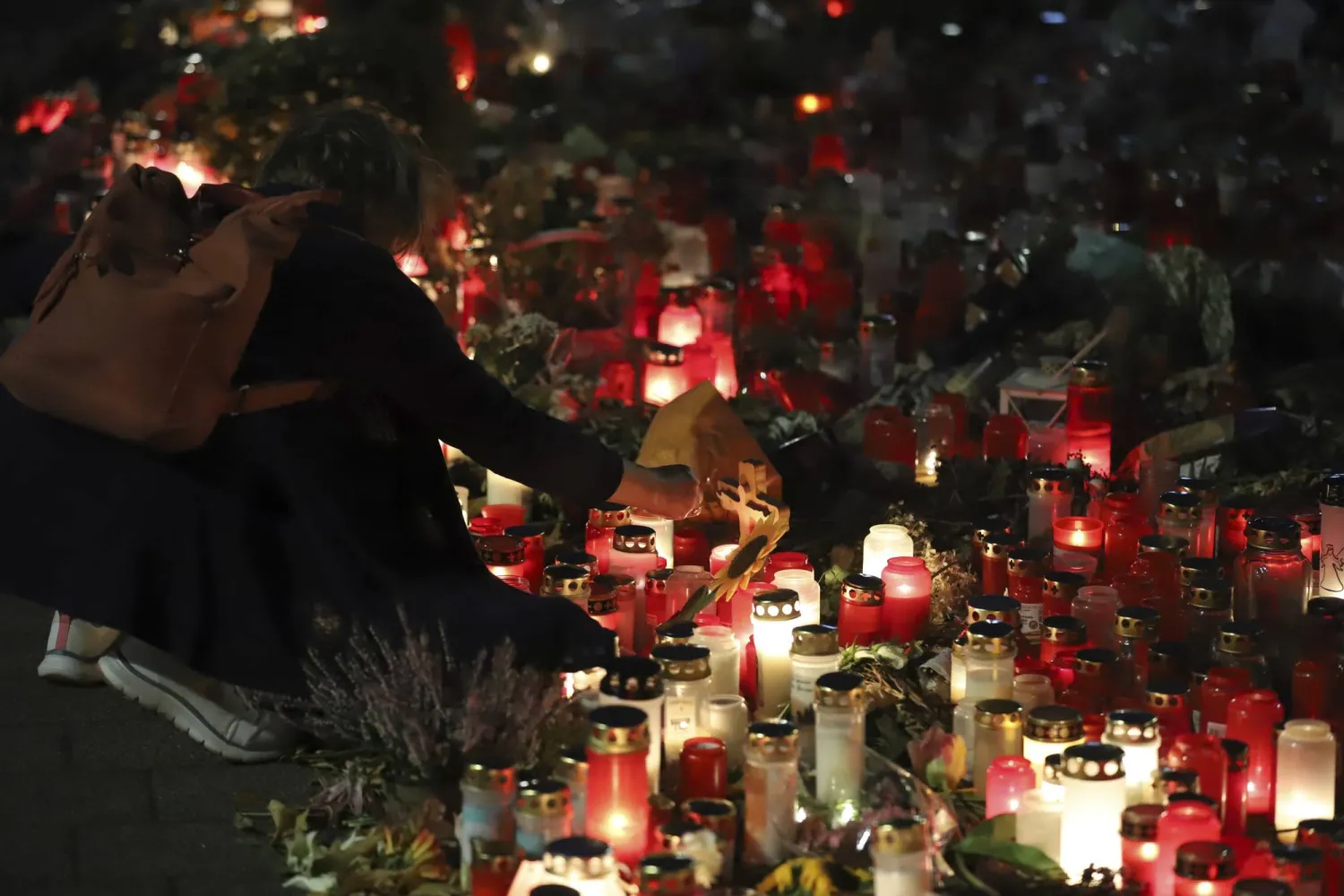 A woman lights a candle at the site of an attack to commemorate the victims late Friday, Aug. 30 2024, in Solingen, Germany. (Sascha Thelen/dpa via AP)