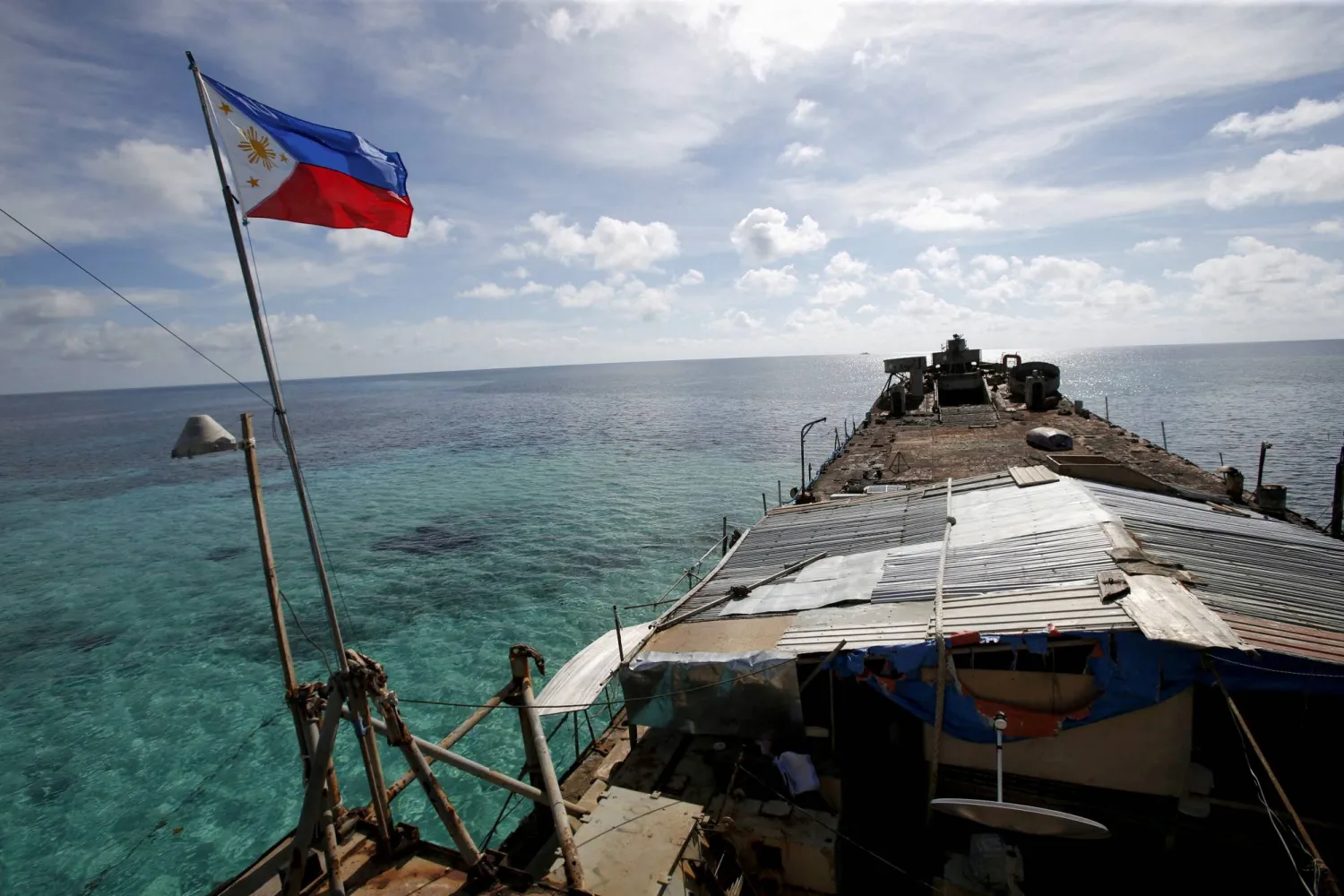 FILE PHOTO: A Philippines flag flutters from BRP Sierra Madre, a dilapidated Philippine Navy ship that has been aground since 1999 and became a Philippine military detachment on the disputed Second Thomas Shoal, part of the Spratly Islands, in the South China Sea March 29, 2014. REUTERS/Erik De Castro/File Photo