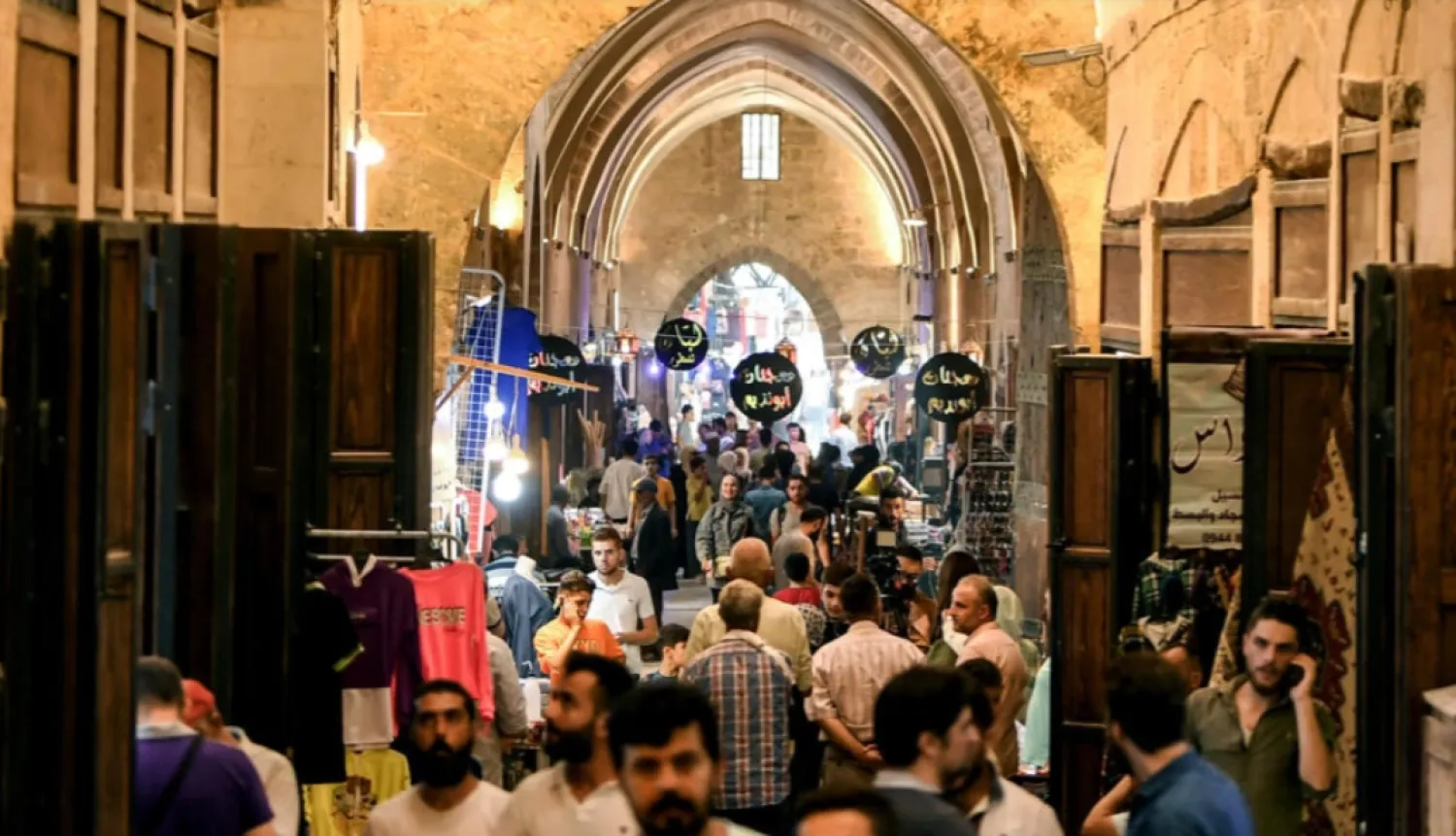People walk along an alley during the reopening of restored bazaars that were damaged during the Syrian conflict in the northern city of Aleppo © - / AFP