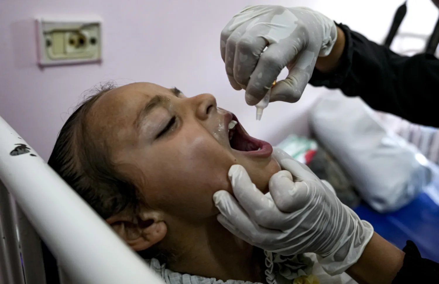 A health worker administers a polio vaccine to a child at a hospital in Khan Younis, Saturday, Aug. 31, 2024. (AP Photo/Abdel Kareem Hana)