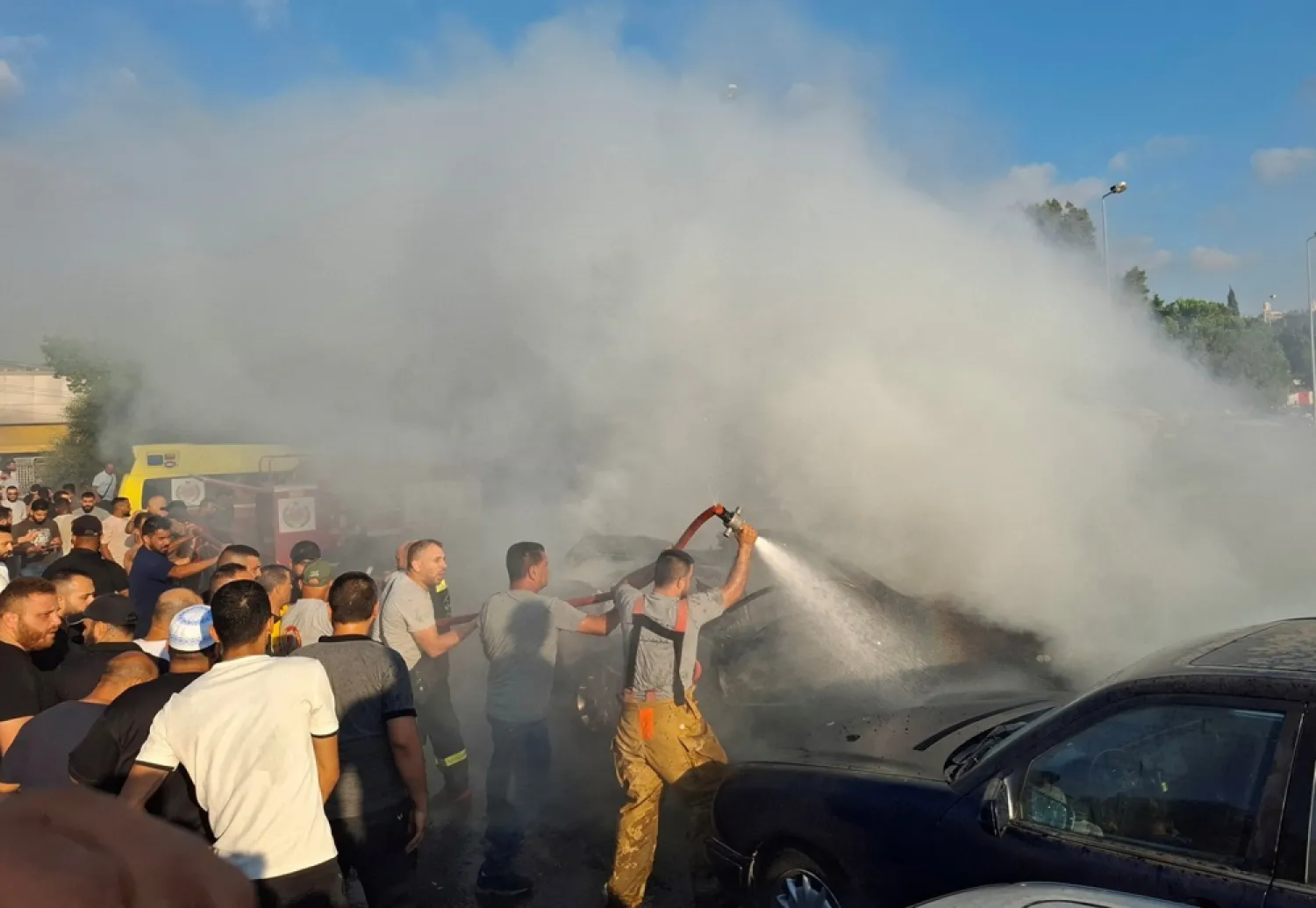 Civil defense members hose down a car after an Israeli airstrike targeted a car on the edge of Lebanon's port city of Sidon, two security sources told Reuters, Lebanon August 9, 2024. (Reuters) 