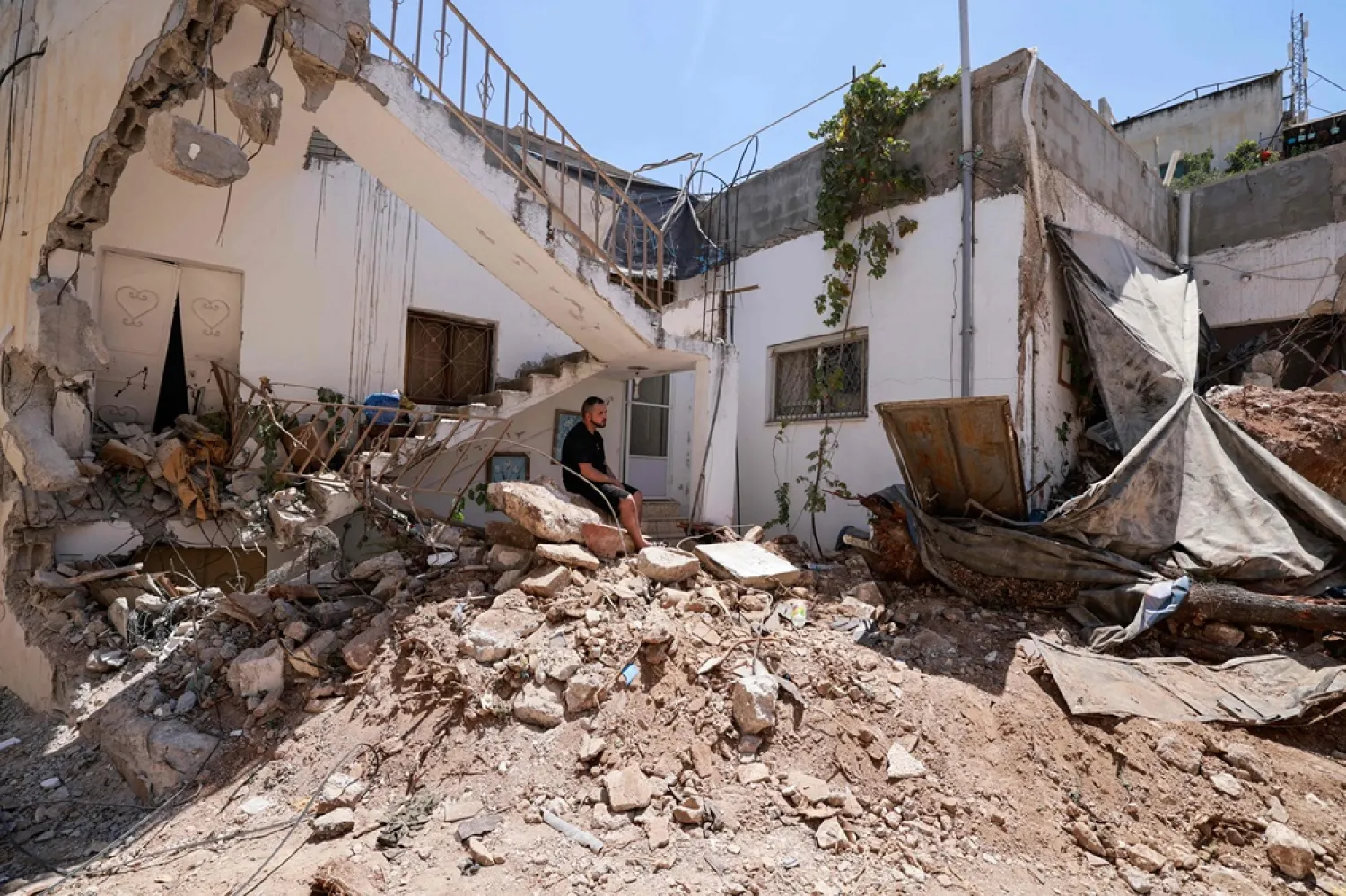  Palestinians inspect the destruction following an Israeli raid in Jenin city in the occupied West Bank on August 6, 2024. (AFP) 
