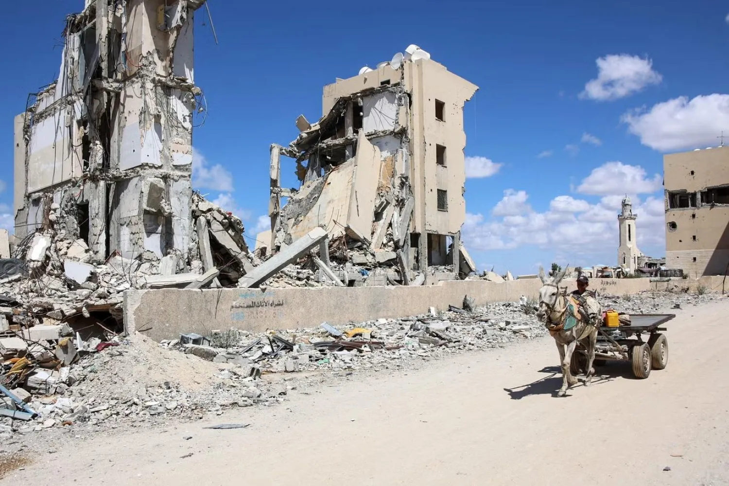 14 Eylül'de Filistinli bir kişi,  Gazze Şeridi'nin kuzeyindeki Beyt Lahya'da, İsrail'in bomba saldırıları sonucunda ağır hasar almış binaların önünde eşek arabasıyla ilerliyor (AFP)