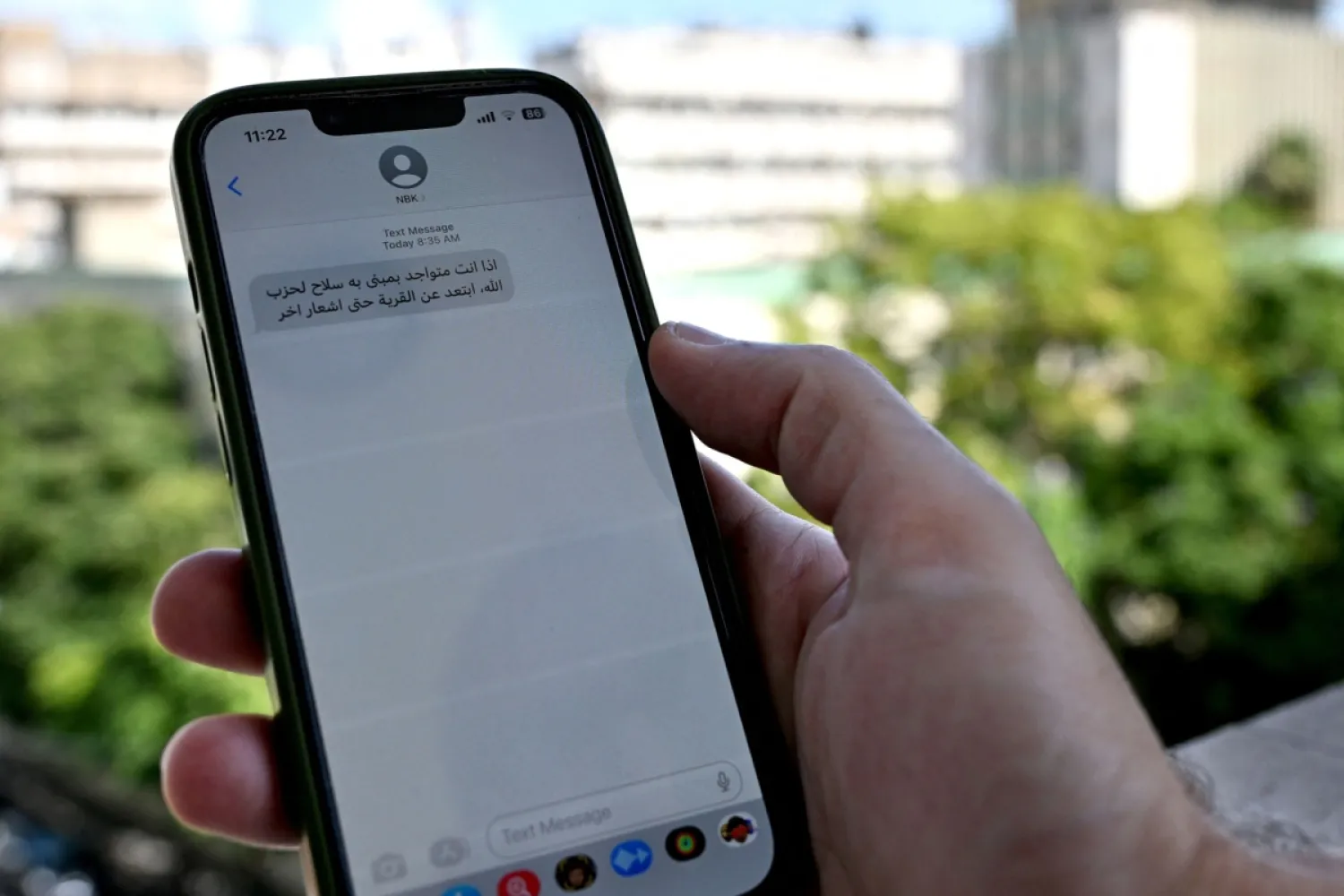 Beyrut'ta Hizbullah’ın silah depolarından uzak durması için cep telefonuna gelen mesajı okuyan Lübnanlı bir adam, 23 Eylül 2024 (AFP)