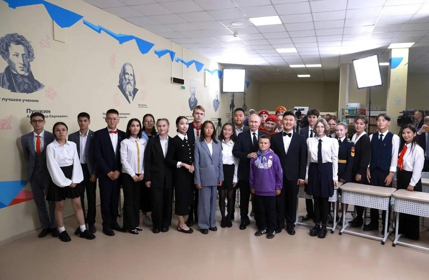 In this pool photograph distributed by the Russian state agency Sputnik, Russia's President Vladimir Putin meets with schoolchildren as he visits a secondary comprehensive school in Kyzyl on September 2, 2024, on the first day of the new school year, known as the Knowledge Day. (Photo by Vyacheslav Prokofyev / Pool / AFP) 