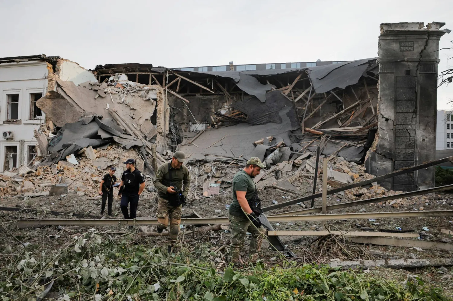 محققون أوكرانيون يتفقدون موقع ضربة صاروخية روسية على كييف (رويترز)