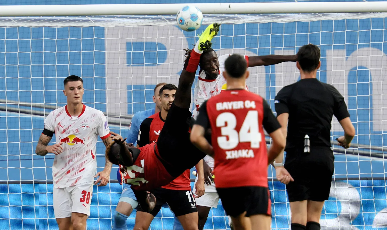 أمادو هايدارا لاعب لايبزيغ لحظة تعرضه لركلة قوية من مهاجم ليفركوزن بونيفيس (إ.ب.أ)