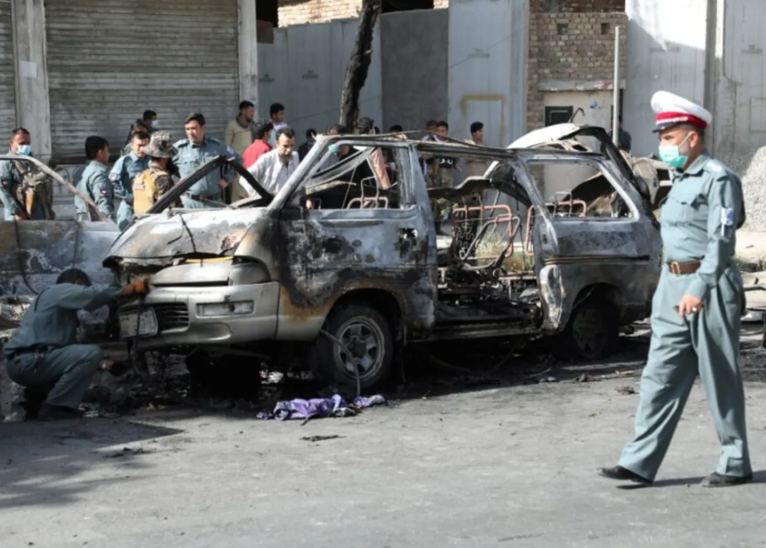 Afghan security forces inspect the wreckage of a passenger van after a blast in Kabul, Afghanistan June 12, 2021.REUTERS/Stringer Purchase Licensing Rights