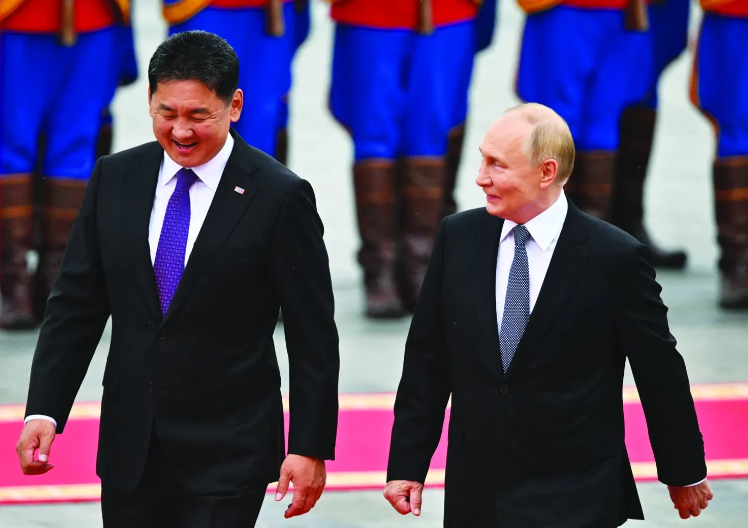 In this pool photograph distributed by the Russian state agency Sputnik, Russia's President Vladimir Putin and Mongolia's President Ukhnaagiin Khurelsukh walk past honor guards during an official welcoming ceremony in Ulaanbaatar on September 3, 2024. (Photo by Kristina Kormilitsyna / POOL / AFP)