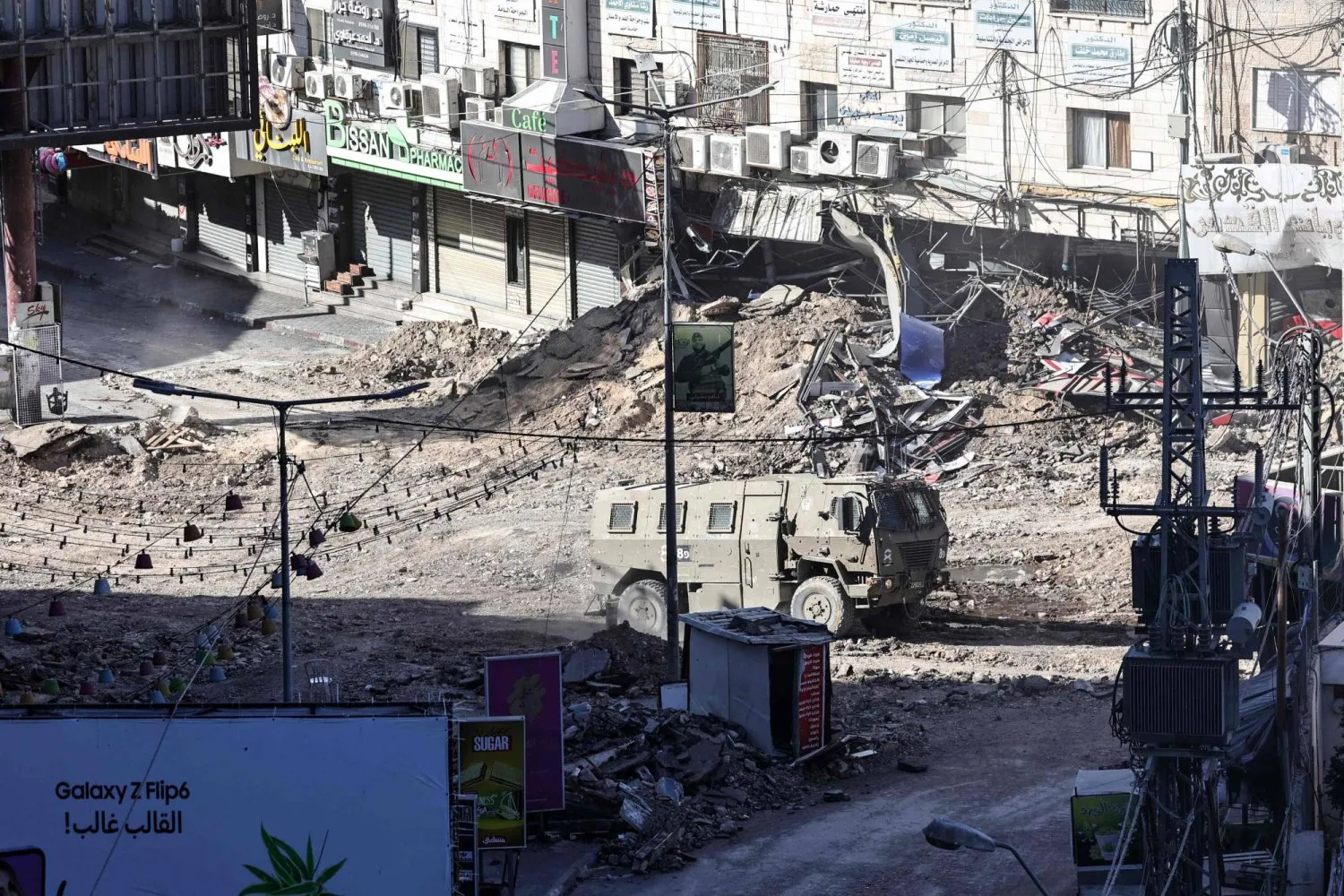 İsrail'e ait zırhlı araç, işgal altındaki Batı Şeria'nın Cenin kentinde yıkılmış bir caddede ilerliyor. (AFP)