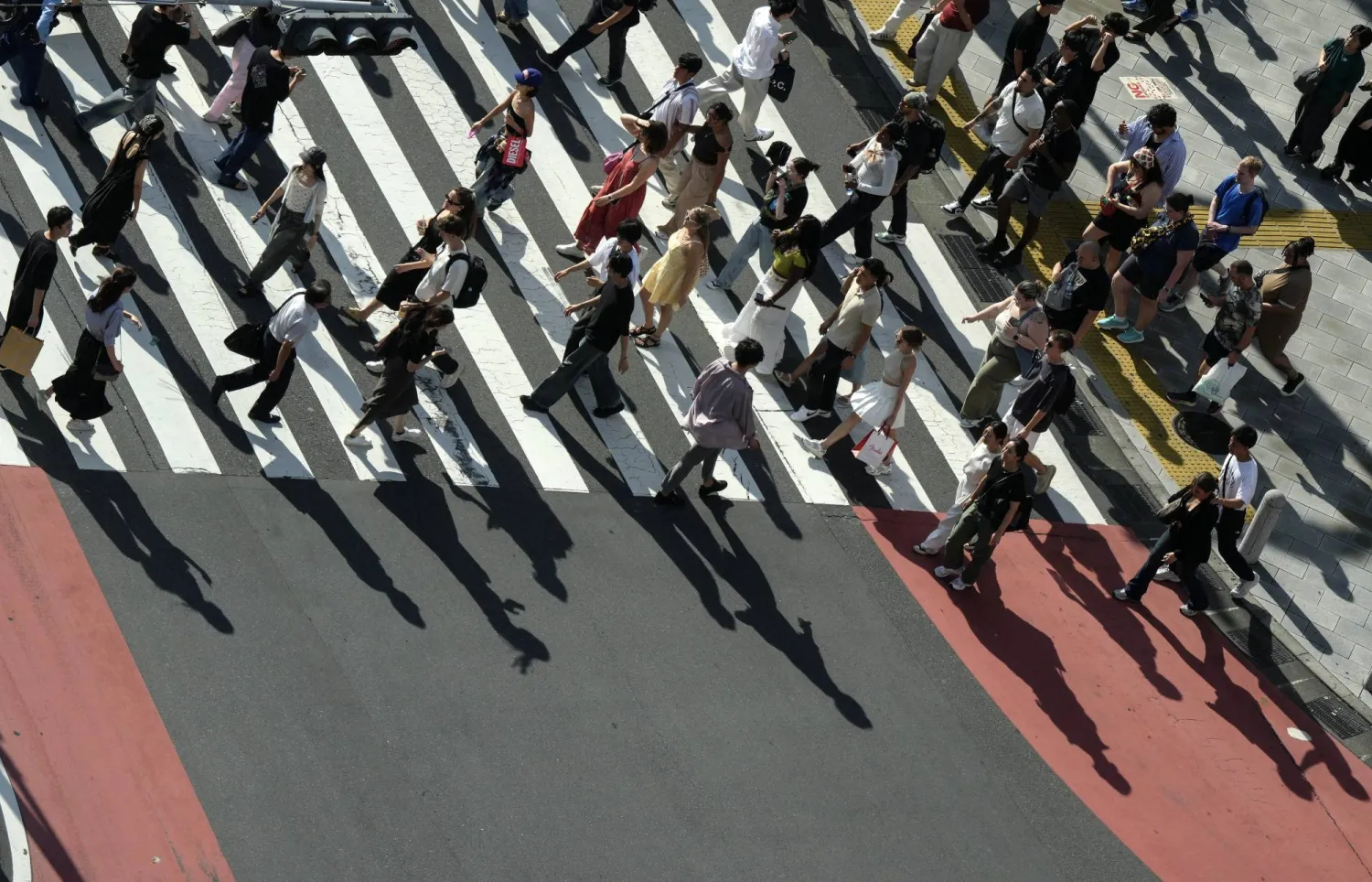 مشاة يعبرون شارعاً مزدحماً في العاصمة اليابانية طوكيو (إ.ب.أ)