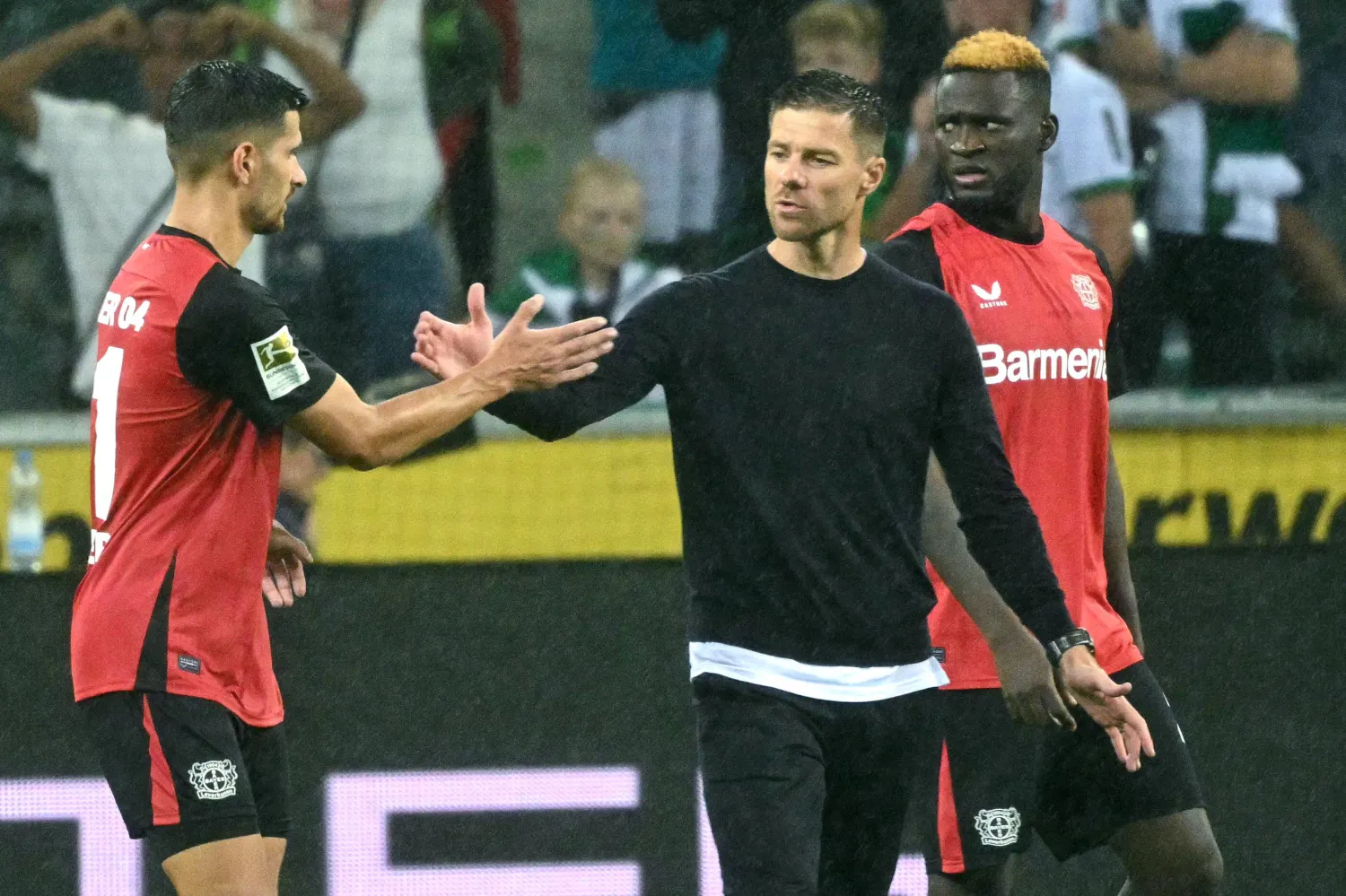 ألونسو يتبادل التحية مع لاعبيه عقب نهاية إحدى المباريات في الدوري الألماني (أ.ف.ب)