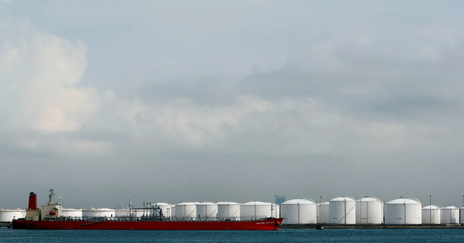 FILE PHOTO: A ship is moored near storage tanks at an oil refinery off the coast of Singapore October 17, 2008.  REUTERS/Vivek Prakash/File Photo