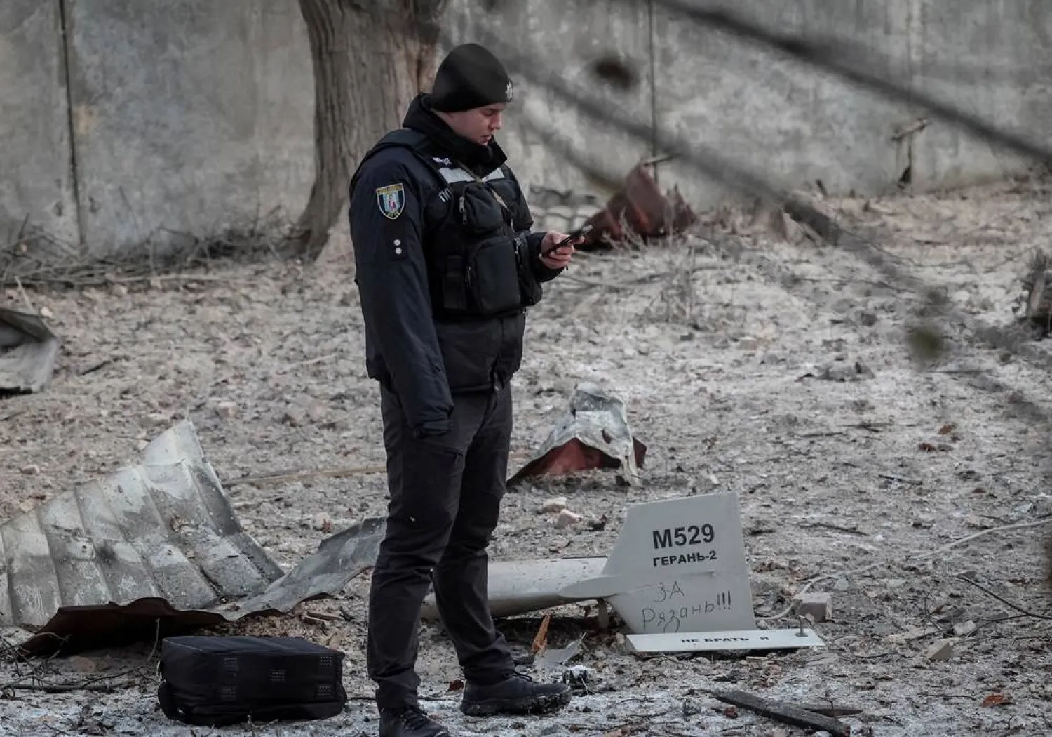 A police officer stands near parts of the drone at the site of a building destroyed by a Russian drone attack, as their attack on Ukraine continues, in Kyiv, Ukraine December 14, 2022. The inscription reads "For Ryazan". (Reuters)