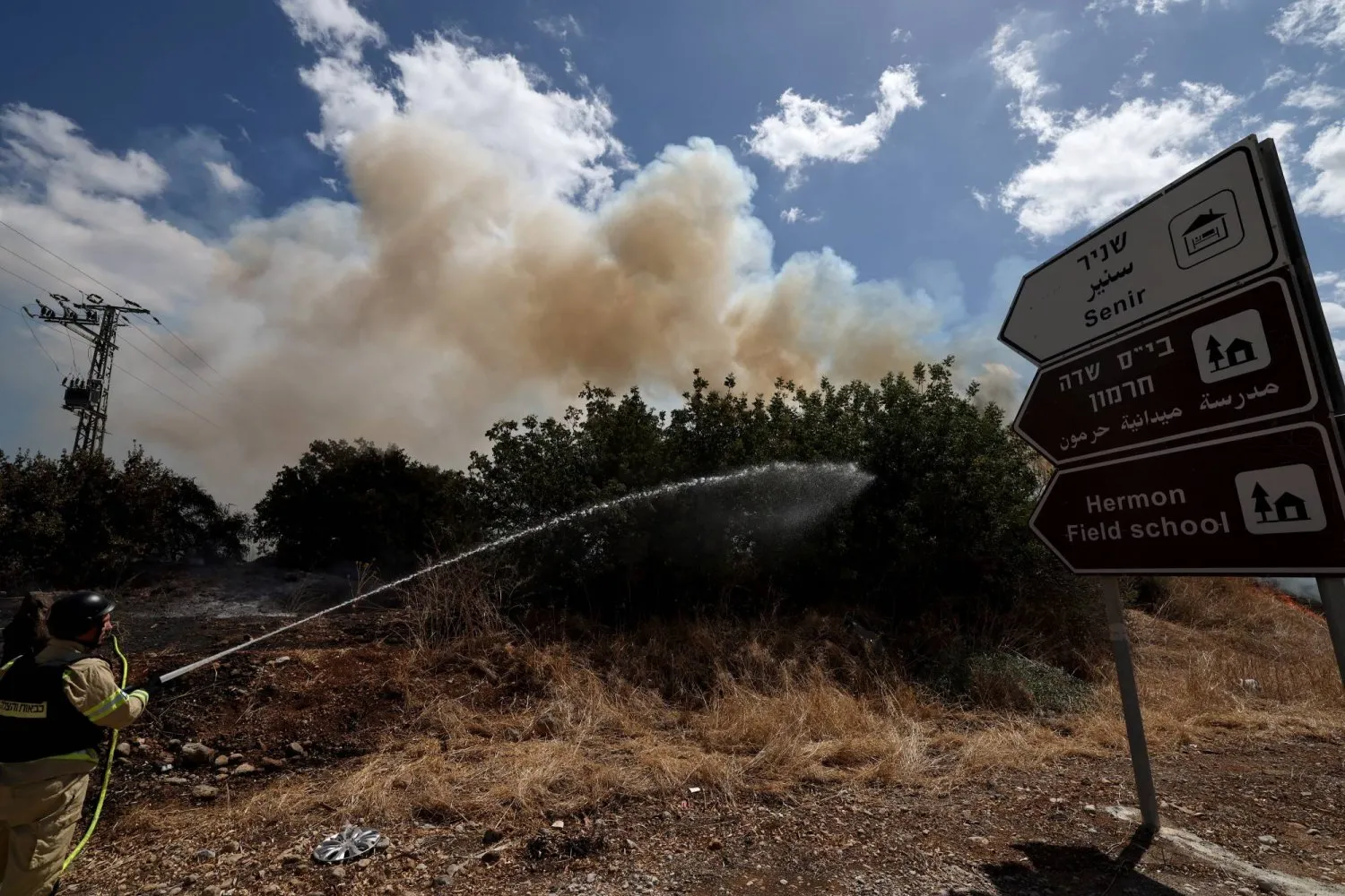 İsrail'in kuzeyinde Hizbullah saldırısı sonucu çıkan yangını söndürmeye çalışan bir itfaiyeci (EPA)