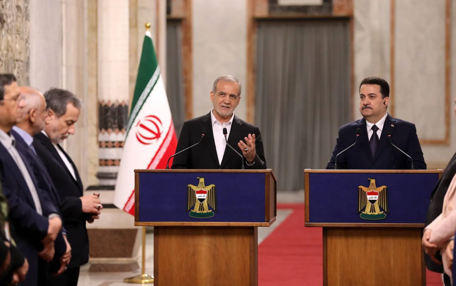 الرئيس الإيراني مسعود بزشكيان (يسار) يتحدث خلال مؤتمر صحافي إلى جانب رئيس الوزراء العراقي محمد شياع السوداني (إ.ب.أ)