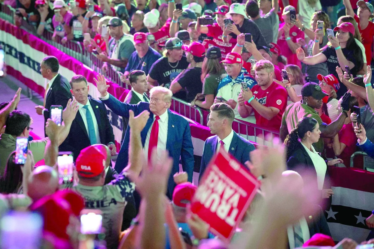 Trump, 17 Eylül'de Michigan'da yapılacak seçim etkinliğinden önce destekçilerini selamlıyor (AFP)