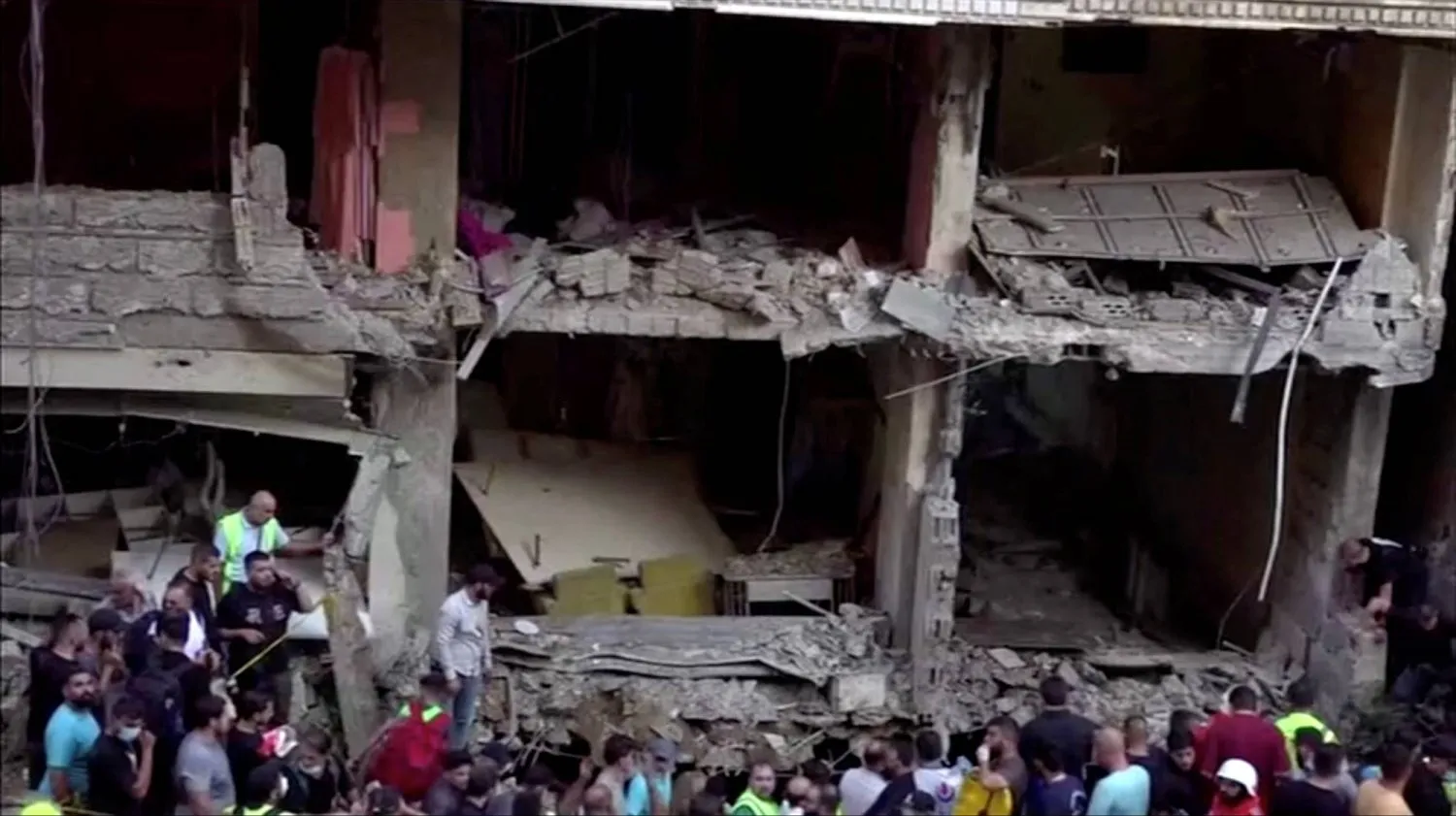 İsrail'in Beyrut'un güney banliyösünde İbrahim Akil'i hedef alan saldırısı sonrasında yıkılan binanın yanındaki kurtarma ekipleri (Reuters)