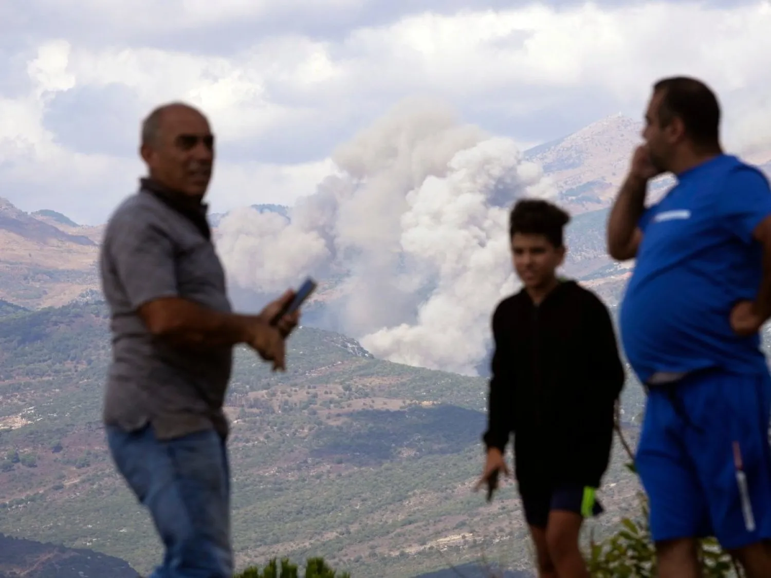 İsrail'in dün gerçekleştirdiği hava saldırısının ardından Mercayun'da dumanların yükseldiği bir bölgeye bakan Lübnanlılar (AP)