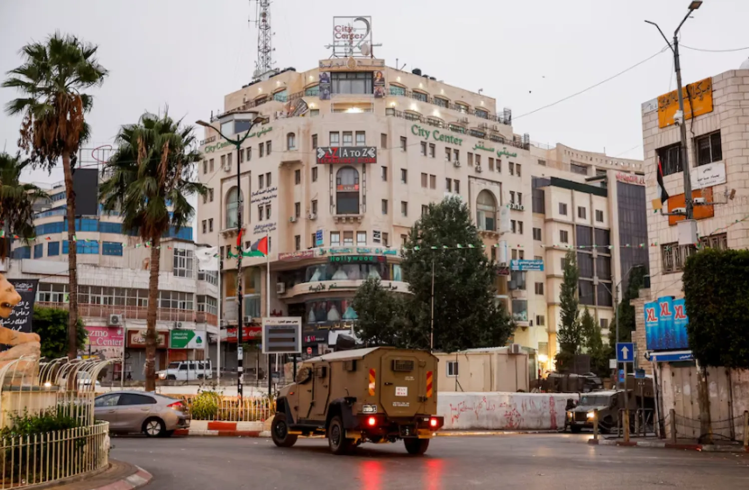 A military vehicle moves in a street outside the building where the Al Jazeera office is located, in Ramallah, in the Israeli-occupied West Bank, September 22, 2024. REUTERS