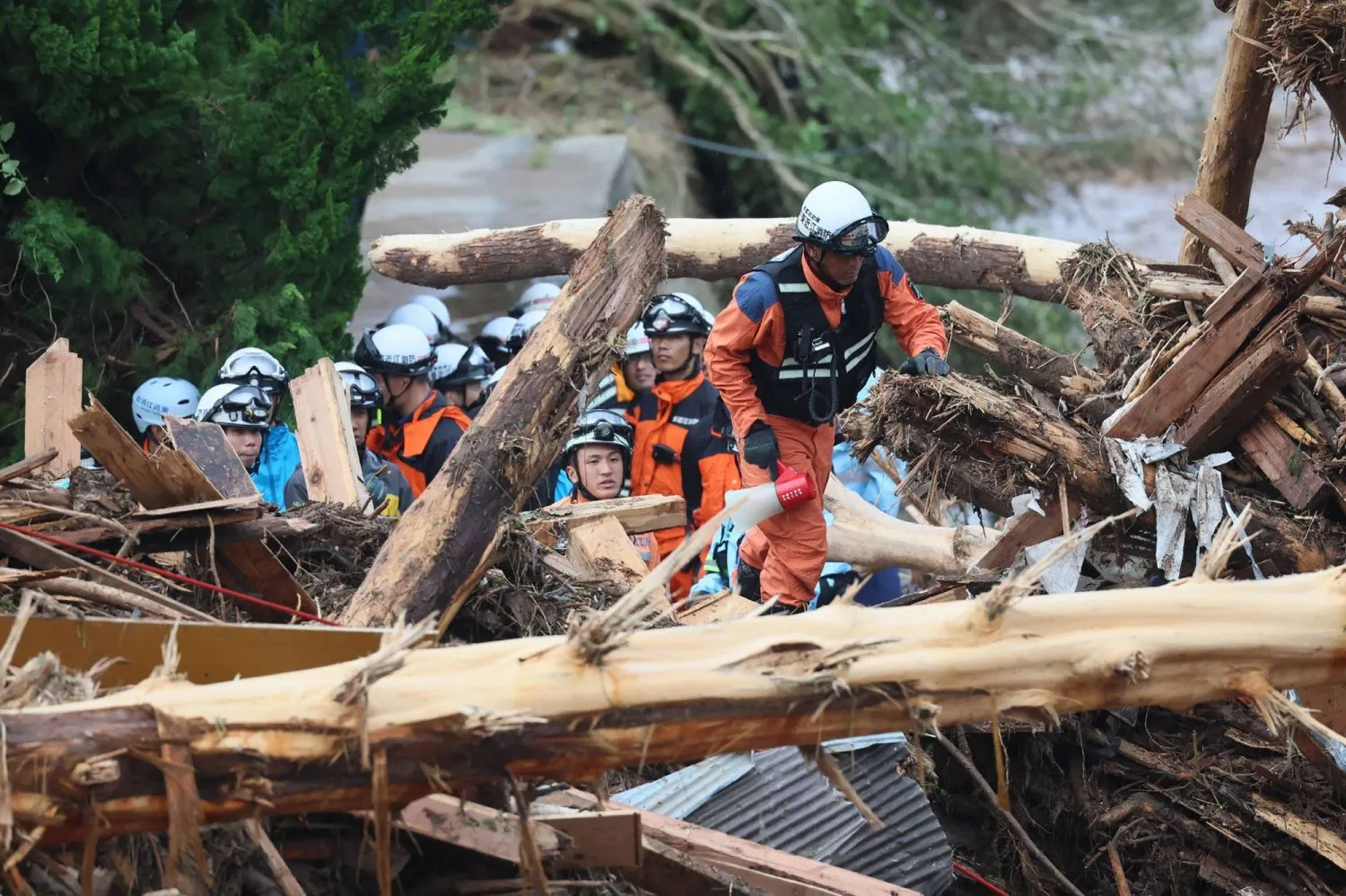 Kurtarma ekipleri, Ishikawa'da şiddetli yağışlar nedeniyle meydana gelen sel ve toprak kaymaları sonucu enkaz altında hayatta kalanları arıyor. (AFP)