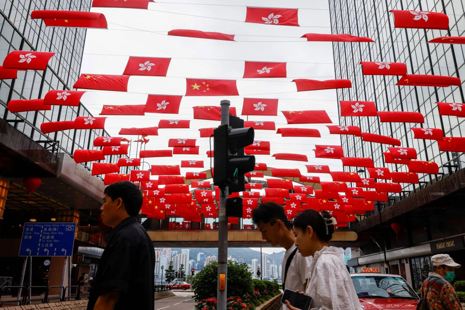 أعلام الصين وهونغ كونغ معلقة أمام أحد المراكز التجارية الكبرى في هونغ كونغ احتفالاً بالعيد الوطني للبلاد (رويترز)