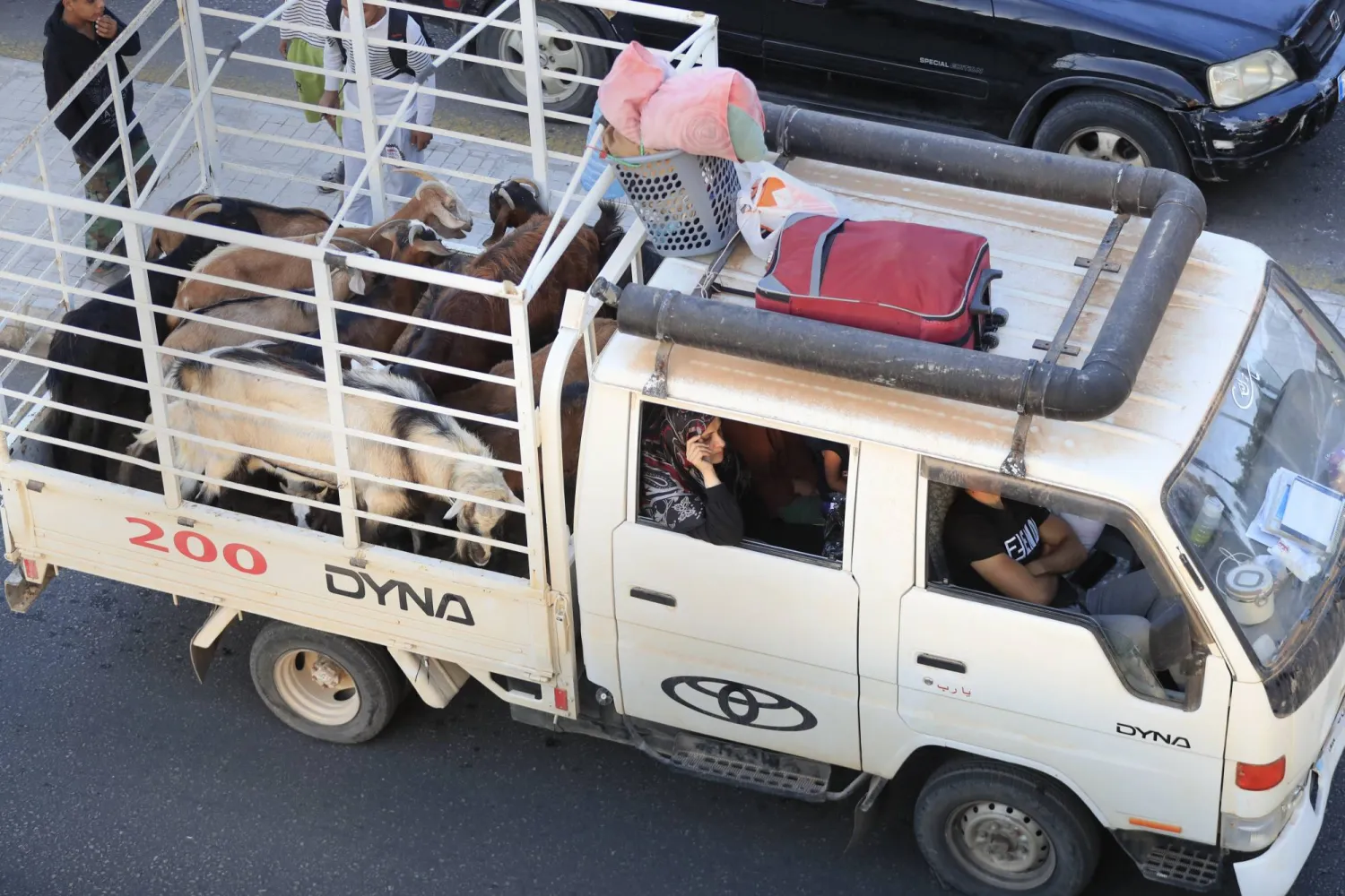 لبنانيون فروا من القرى الجنوبية وسط الغارات الجوية الإسرائيلية المستمرة في سيارة «بيك آب» على طريق سريعة تربط بين مدينة بيروت في مدينة صيدا الساحلية الجنوبية (أ.ب)