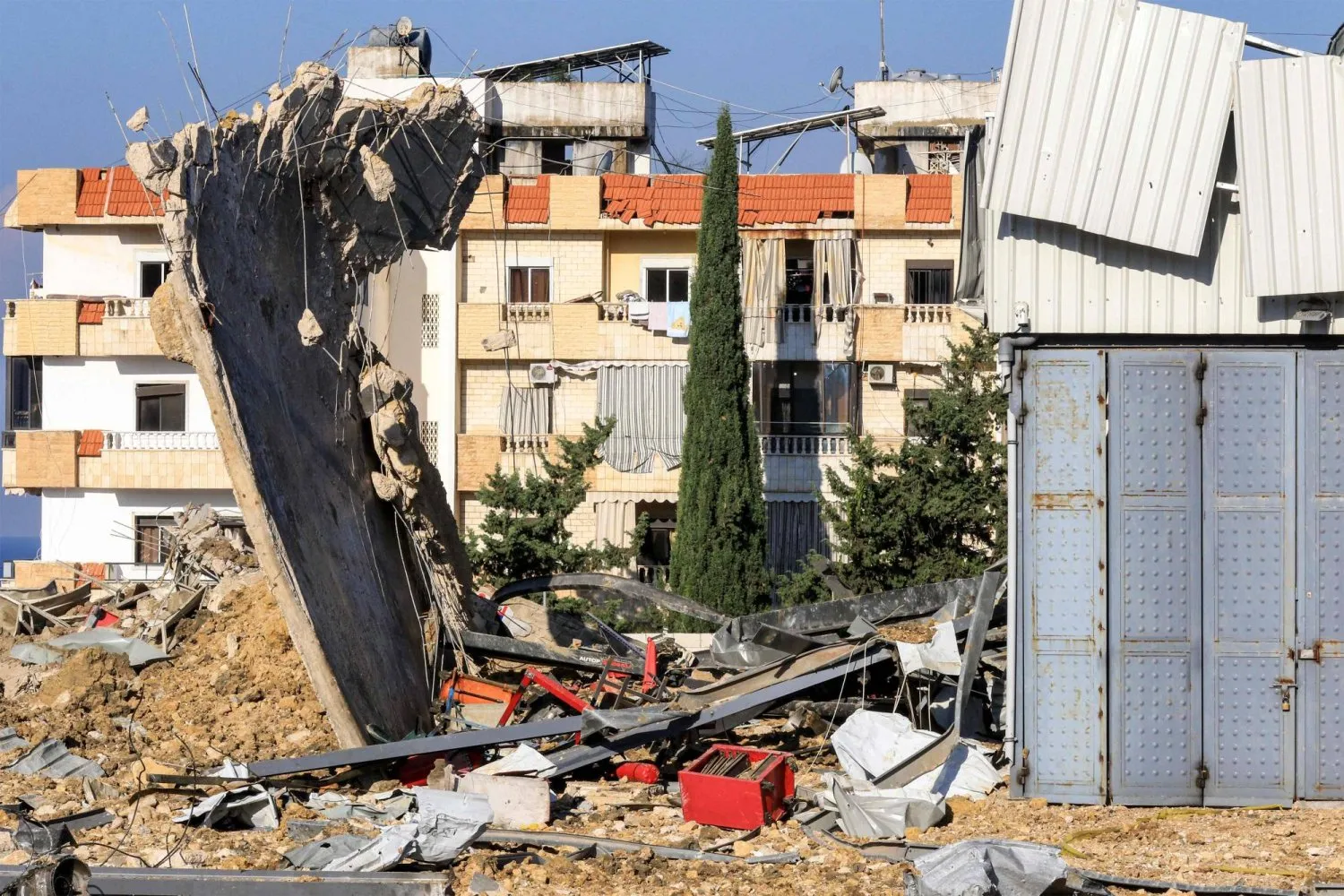 Beyrut'u güneydeki Sayda şehrine bağlayan yol üzerindeki Ciyeh'de İsrail hava saldırısı sonucu yıkılan bir depo (AFP)