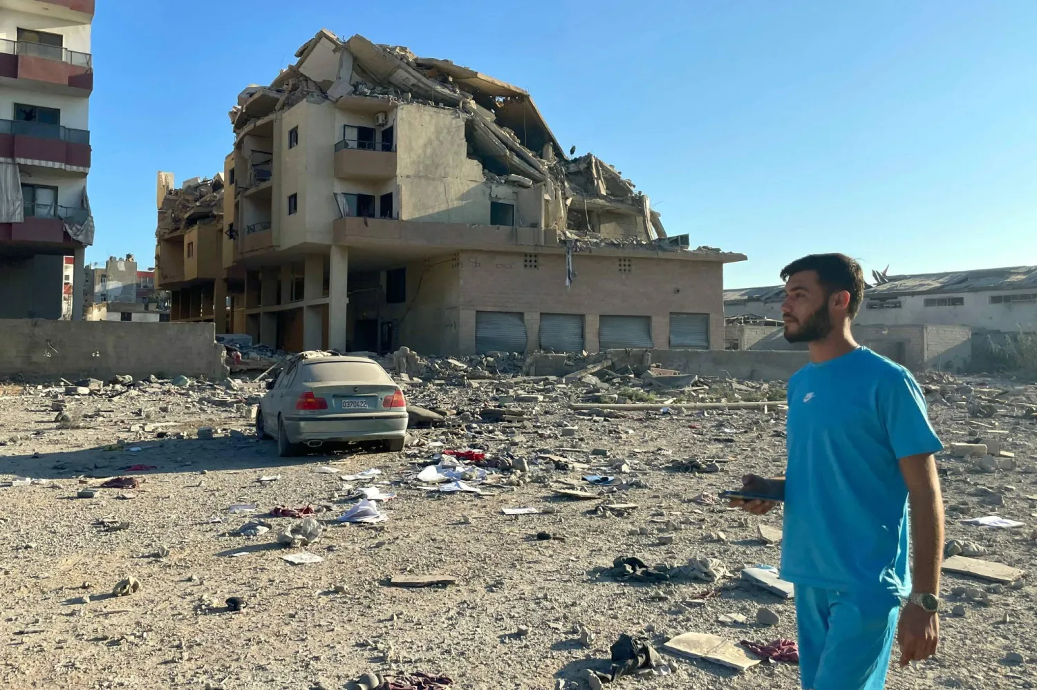 A man walks past destruction caused by Israeli airstrikes in the Masaken neighborhood on the outskirts of Tyre, Lebanon on September 26, 2024.  (Photo by Hassan FNEICH / AFP)