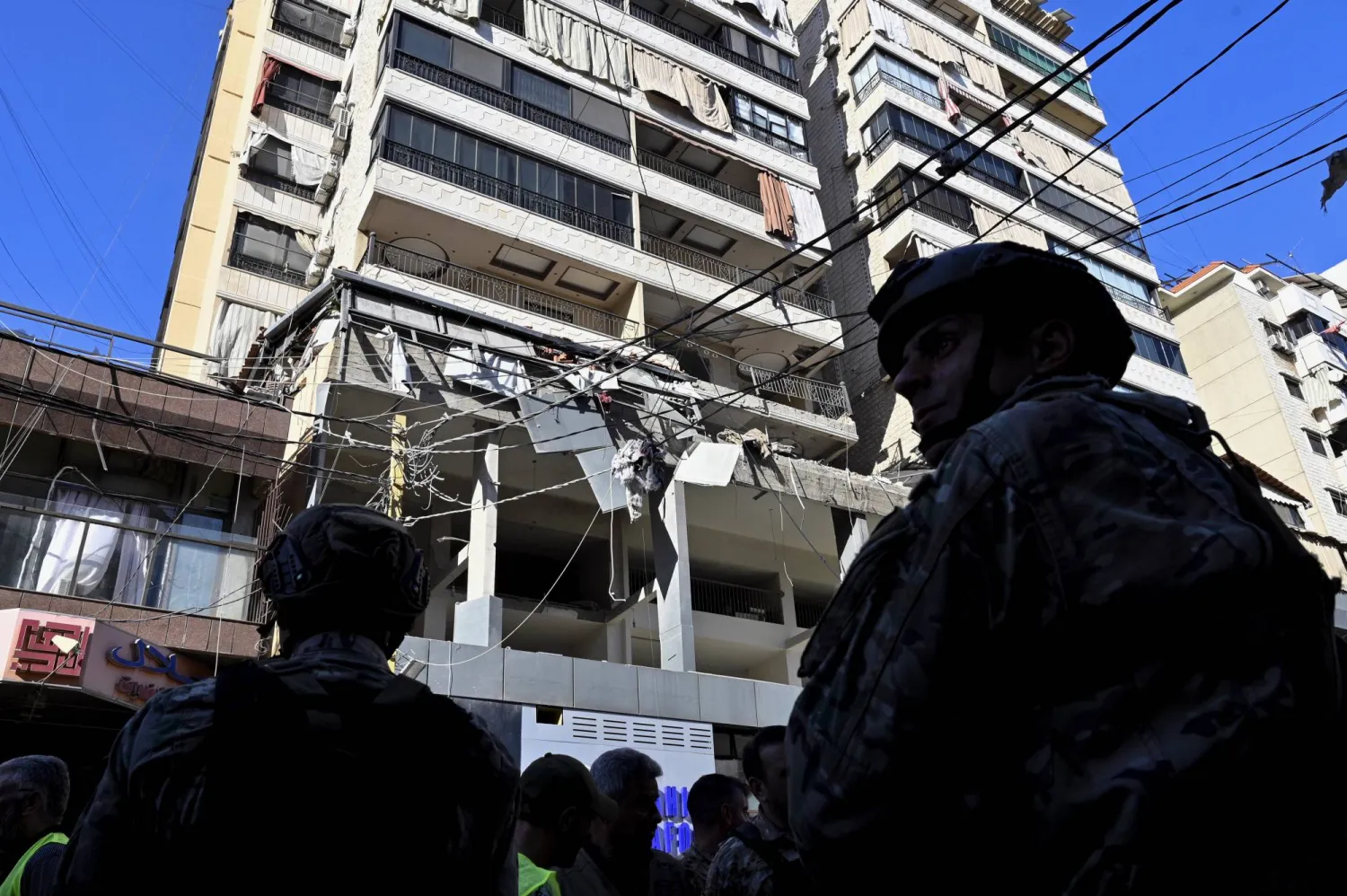 Lebanese army soldiers and residents stand in front of a damaged building in the southern suburb of Beirut following an Israeli raid, in Beirut, Lebanon, 26 September 2024. EPA/WAEL HAMZEH