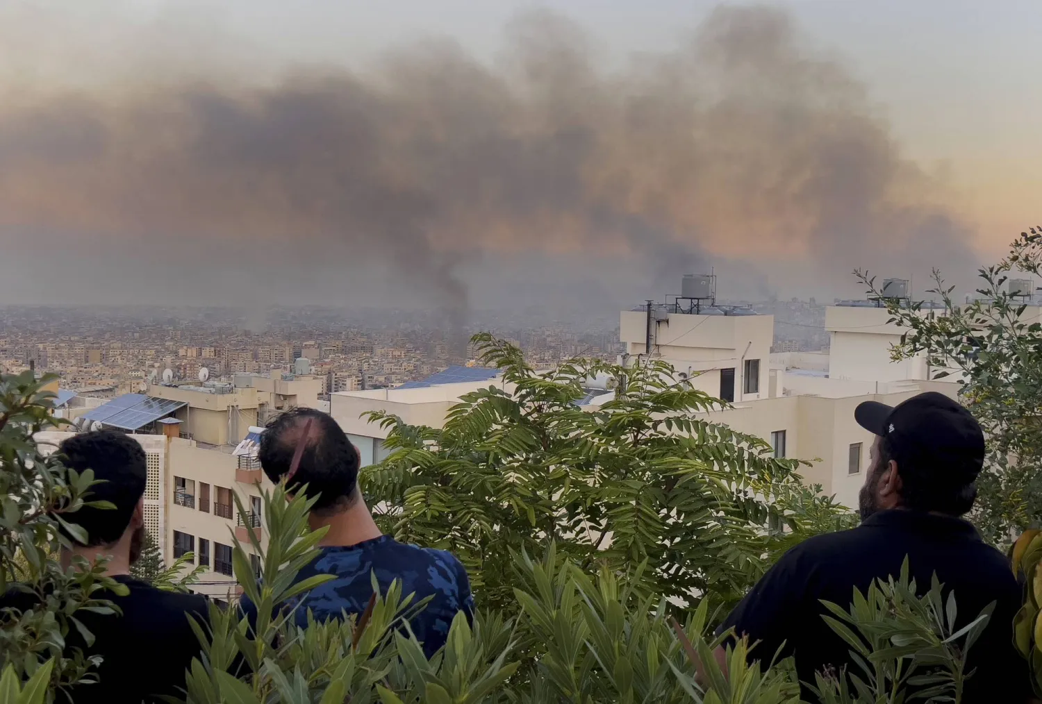 مواطنون يشاهدون تصاعد الدخان بعد قصف إسرائيلي طال الضاحية الجنوبية لبيروت (أ.ب)