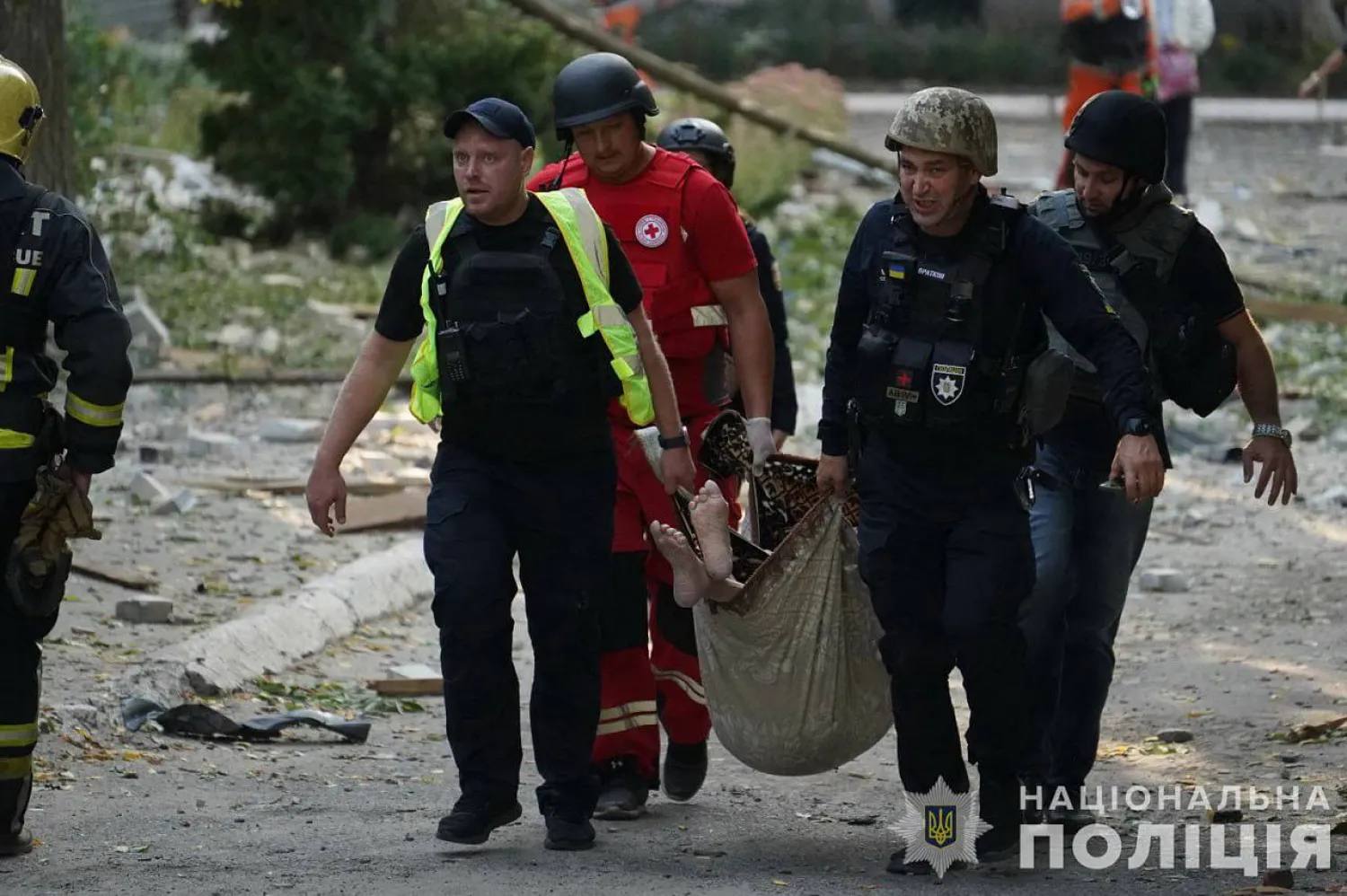 This handout photograph taken and released by the Ukrainian National Police on September 19, 2024 shows police officers carrying a victim of an airstrike on a geriatric center in the city of Sumy, amid the Russian invasion in Ukraine. (Photo by Handout / UKRAINIAN NATIONAL POLICE / AFP)